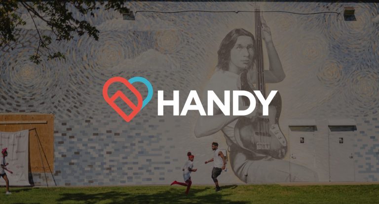 IU C&I Studios Page Handy logo on background of people running by a large mural on the side of a building
