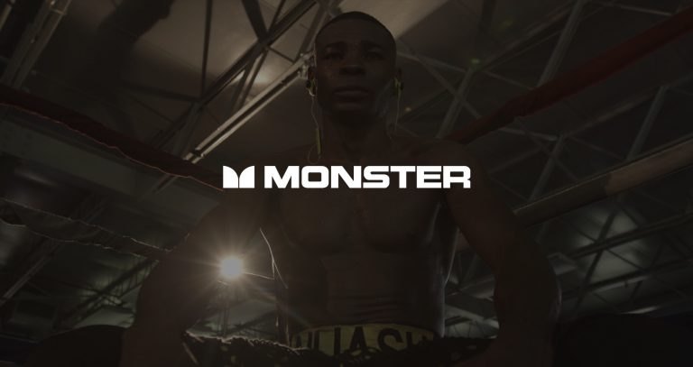 White Monster Music Cable Logo with dimmed background of African American boxer standing in the corner of a ring