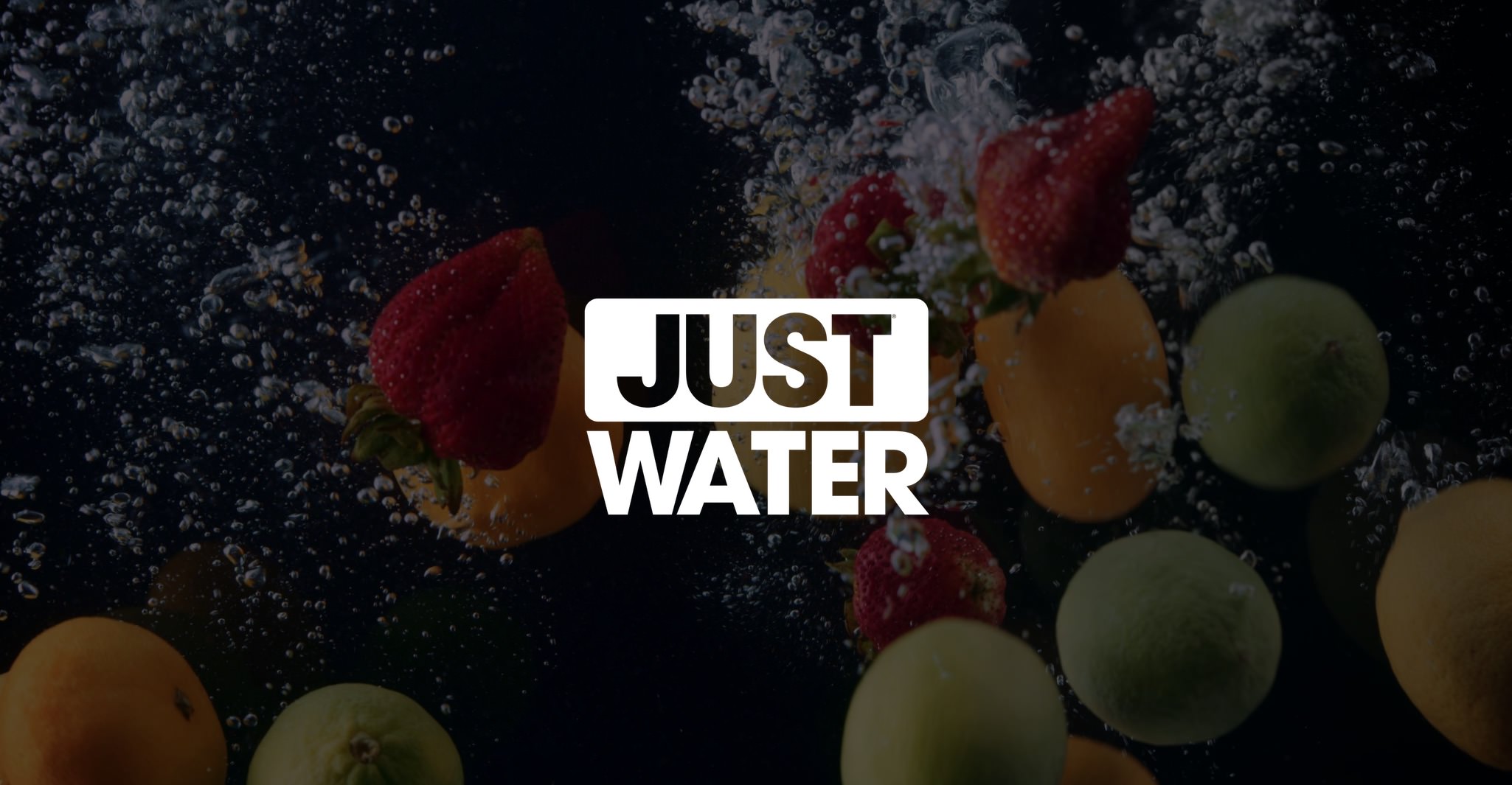 White Just Water logo with dimmed background of fruit underwater with bubbles