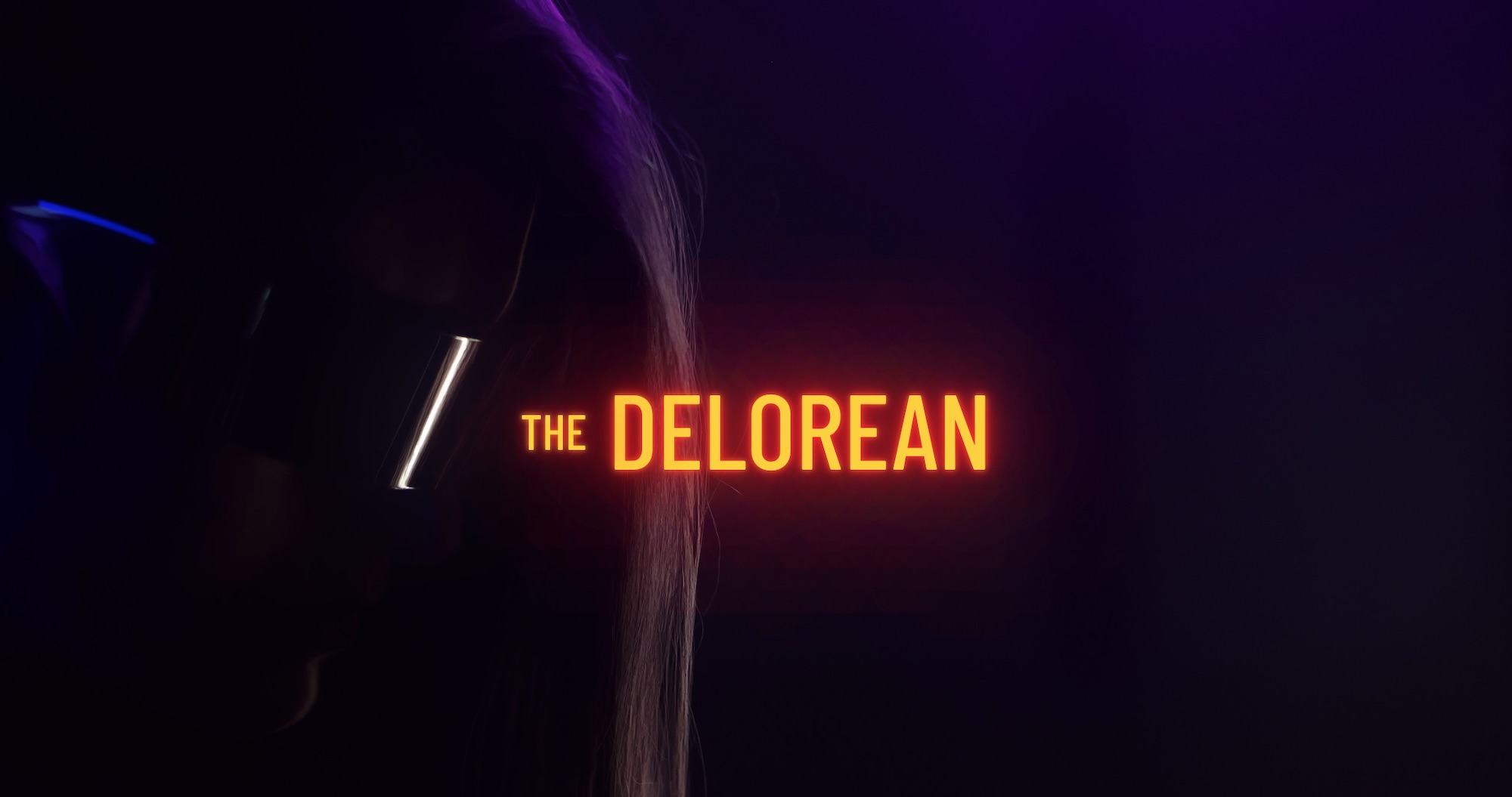 Orange The Delorian title with background showing woman wearing shades in semi darkness
