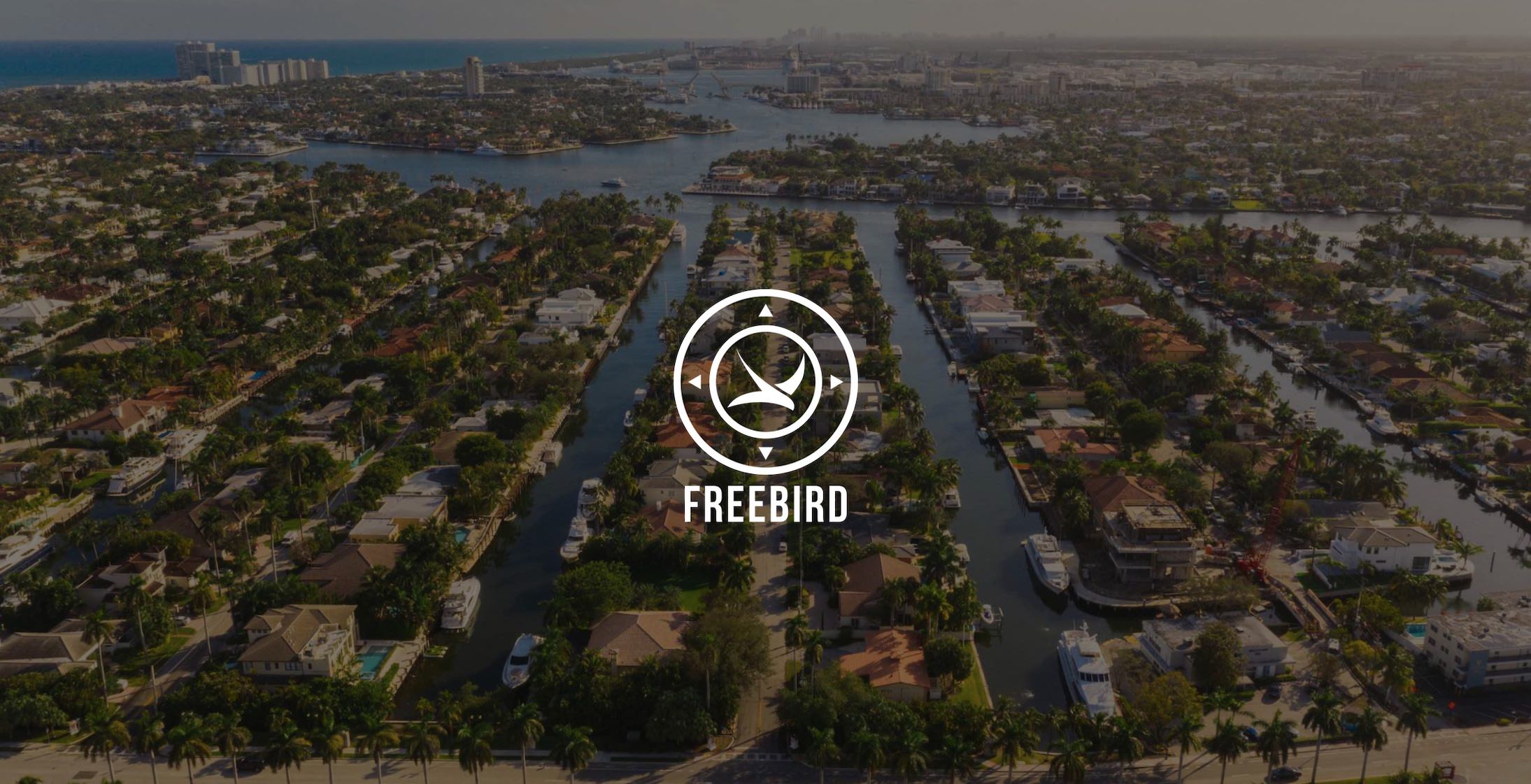 White FreeBird logo on background of canals with boats in a city