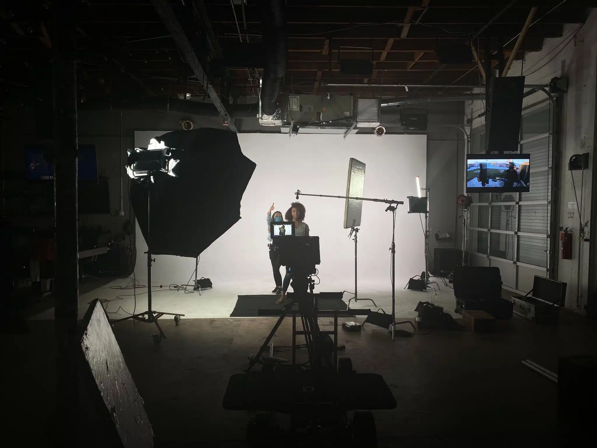 View from behind camera of woman and female crew member on set