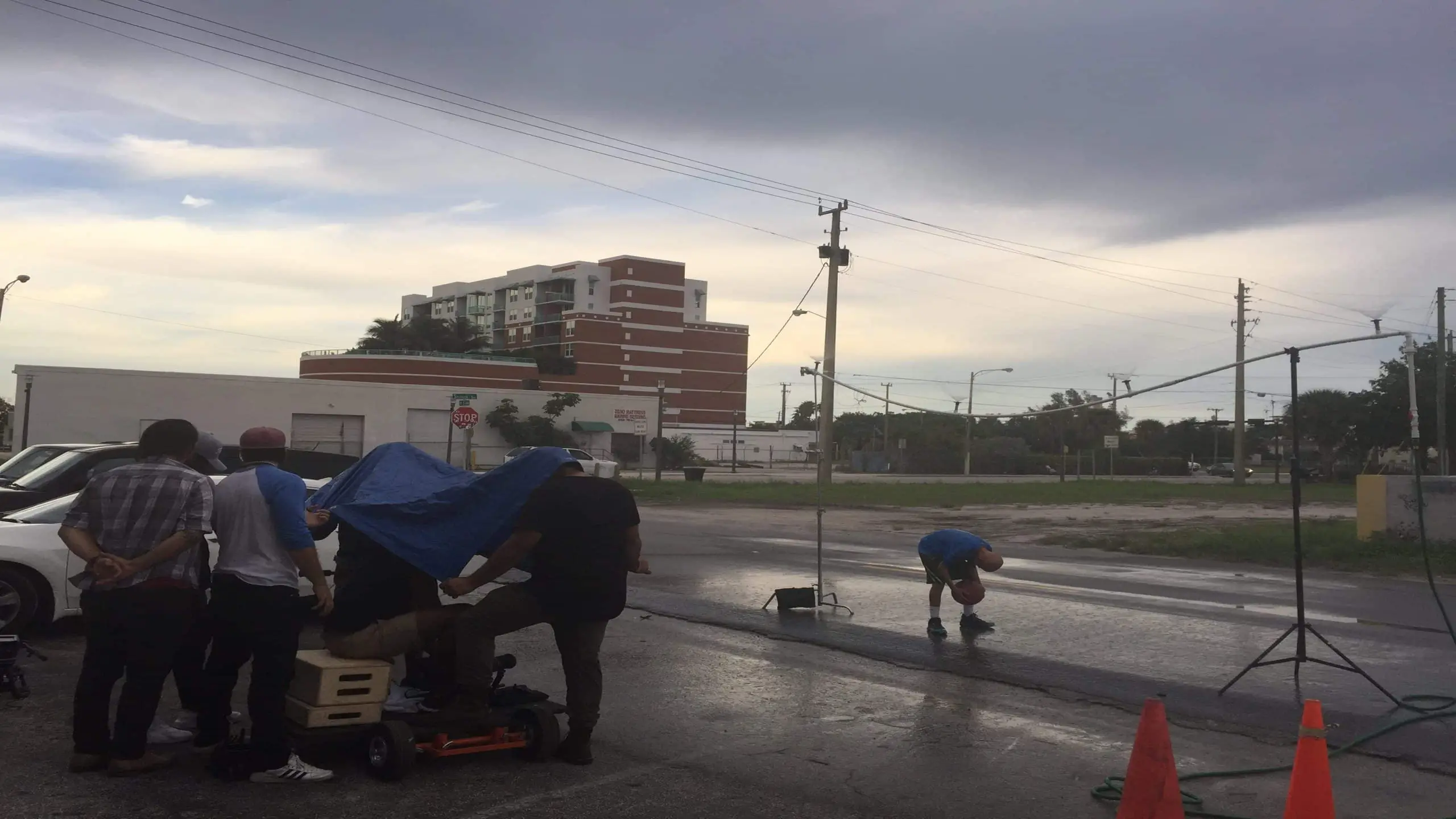 cis-page-what-is-alopecia5 Bald man being filmed dribbling a basketball on set outside the studios with a crew filming and looking on