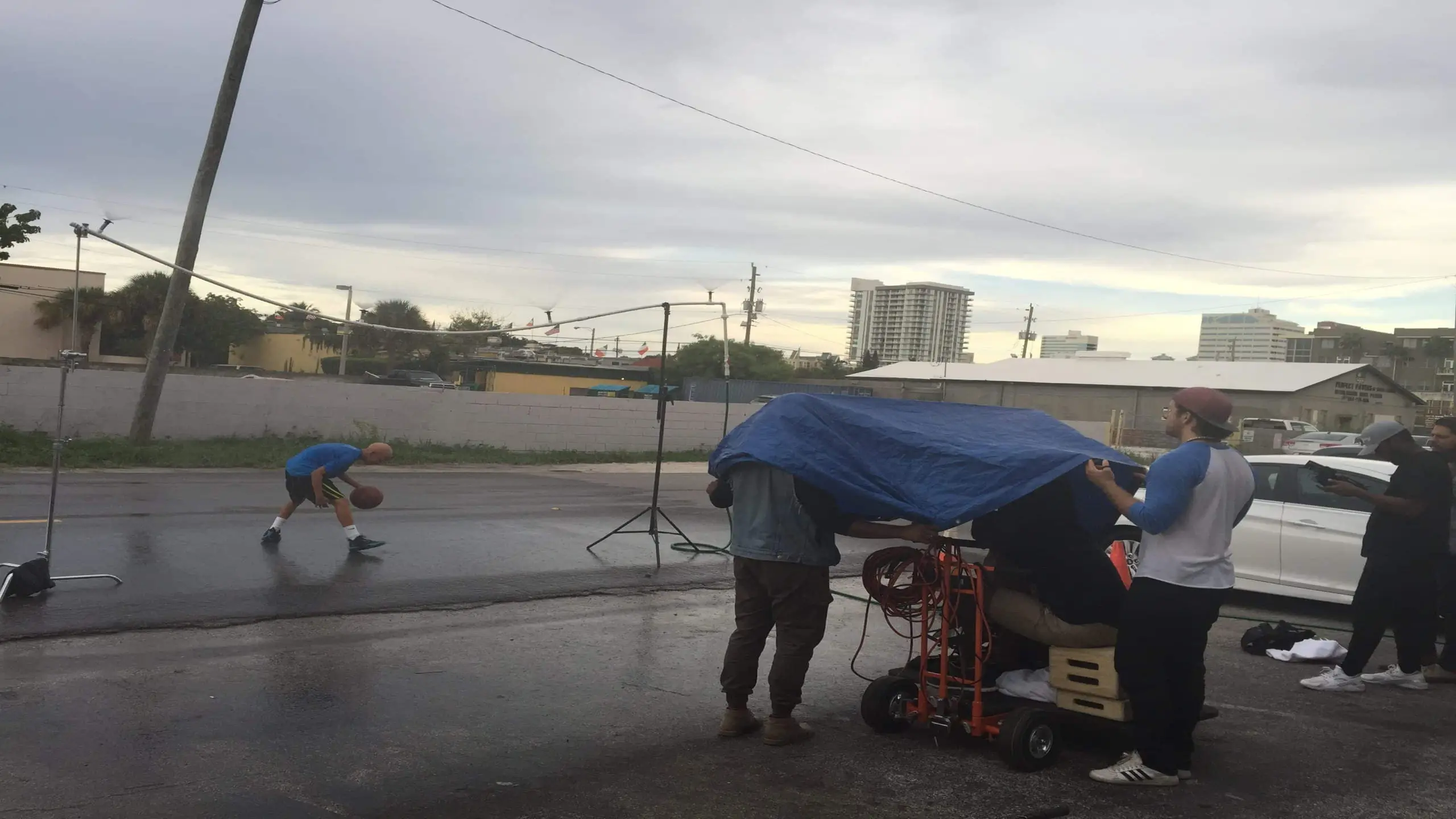 cis-page-what-is-alopecia6 Bald man being filmed dribbling a basketball on set outside the studios with a crew filming and looking on