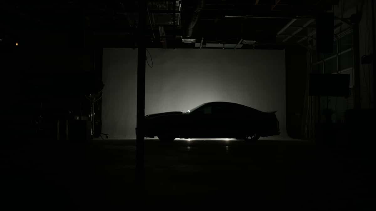 Side profile silhouette of Ford Mustang in semidarkness