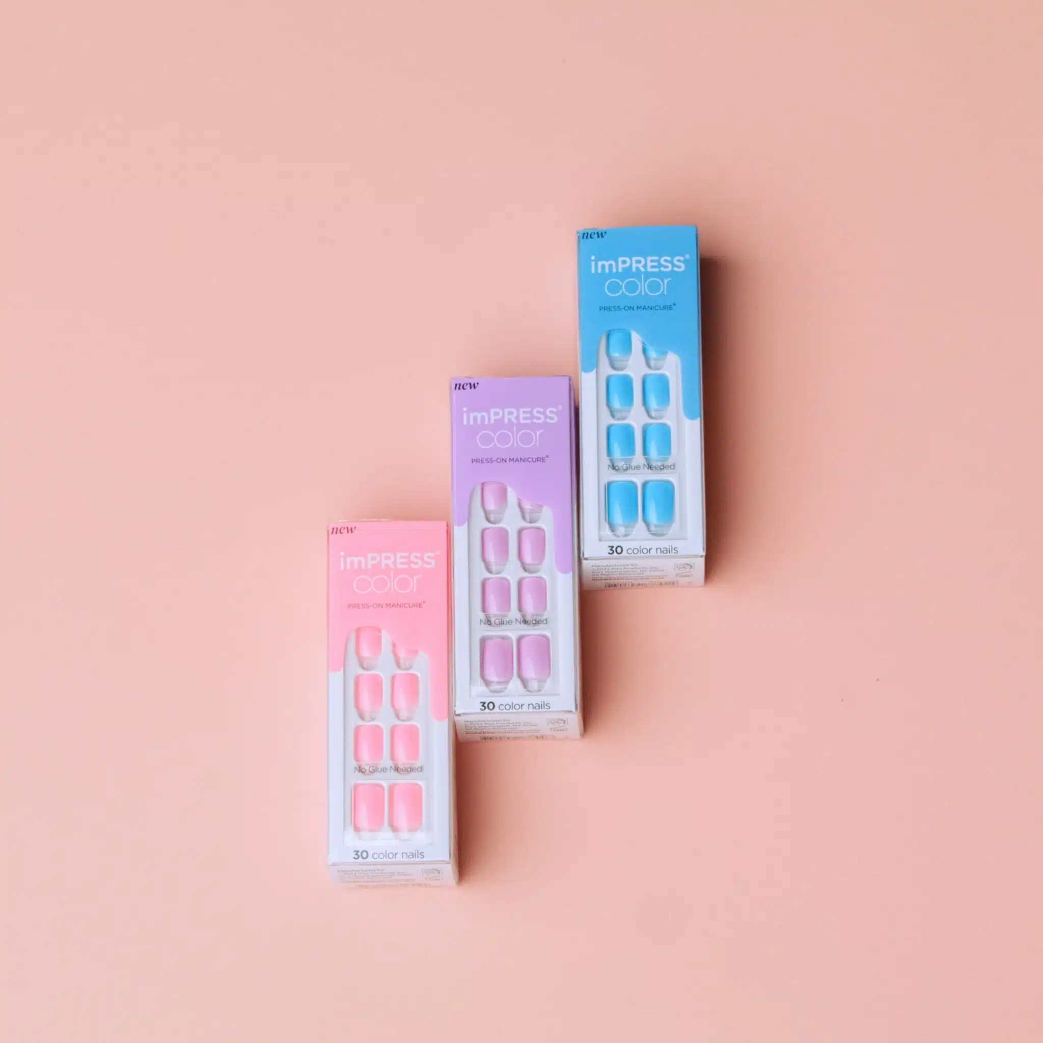 KISS 17 Light pink, purple and blue nail packages on display against a pink background