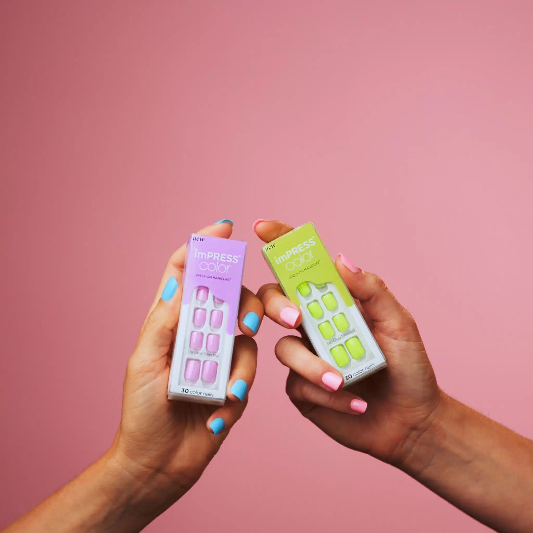 KISS 19 Closeup of lime green and pink colored nails being held by two different women wearing light blue and pink nails respectively