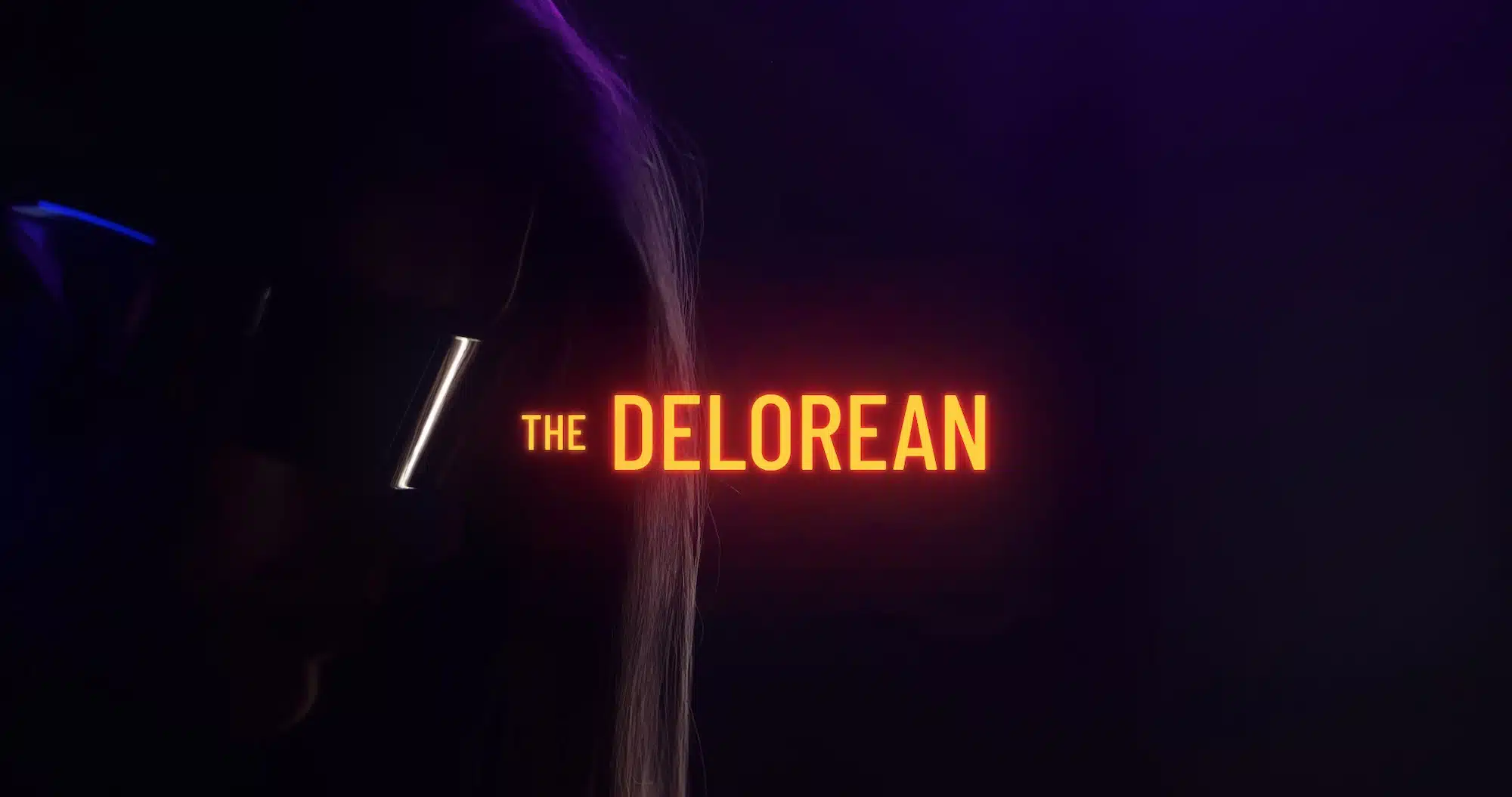 Orange The Delorian title with background showing woman wearing shades in semi darkness