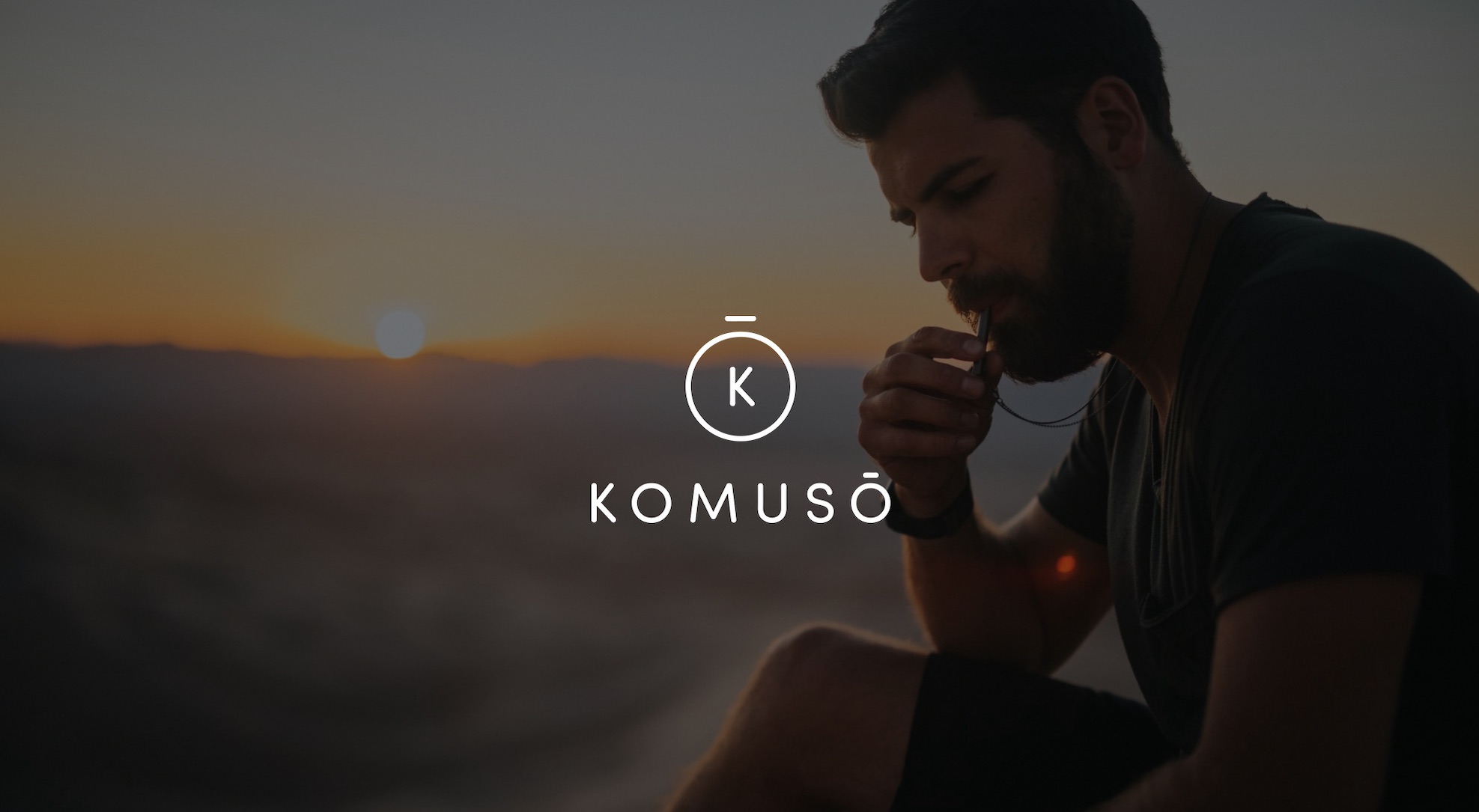 Keyword: Professional photography services .White Komuso logo Photo Services with background of bearded man blowing whistle with sun setting in the distance