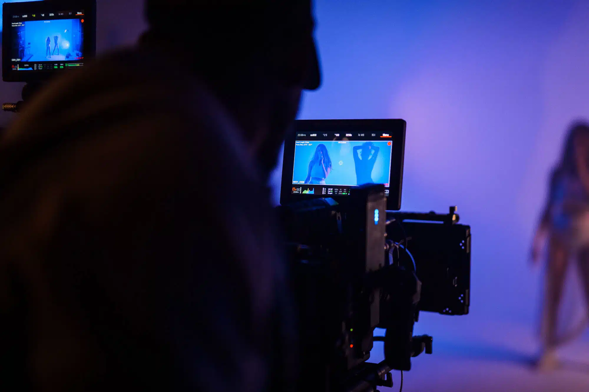 View from behind of cameraman filming a woman on set