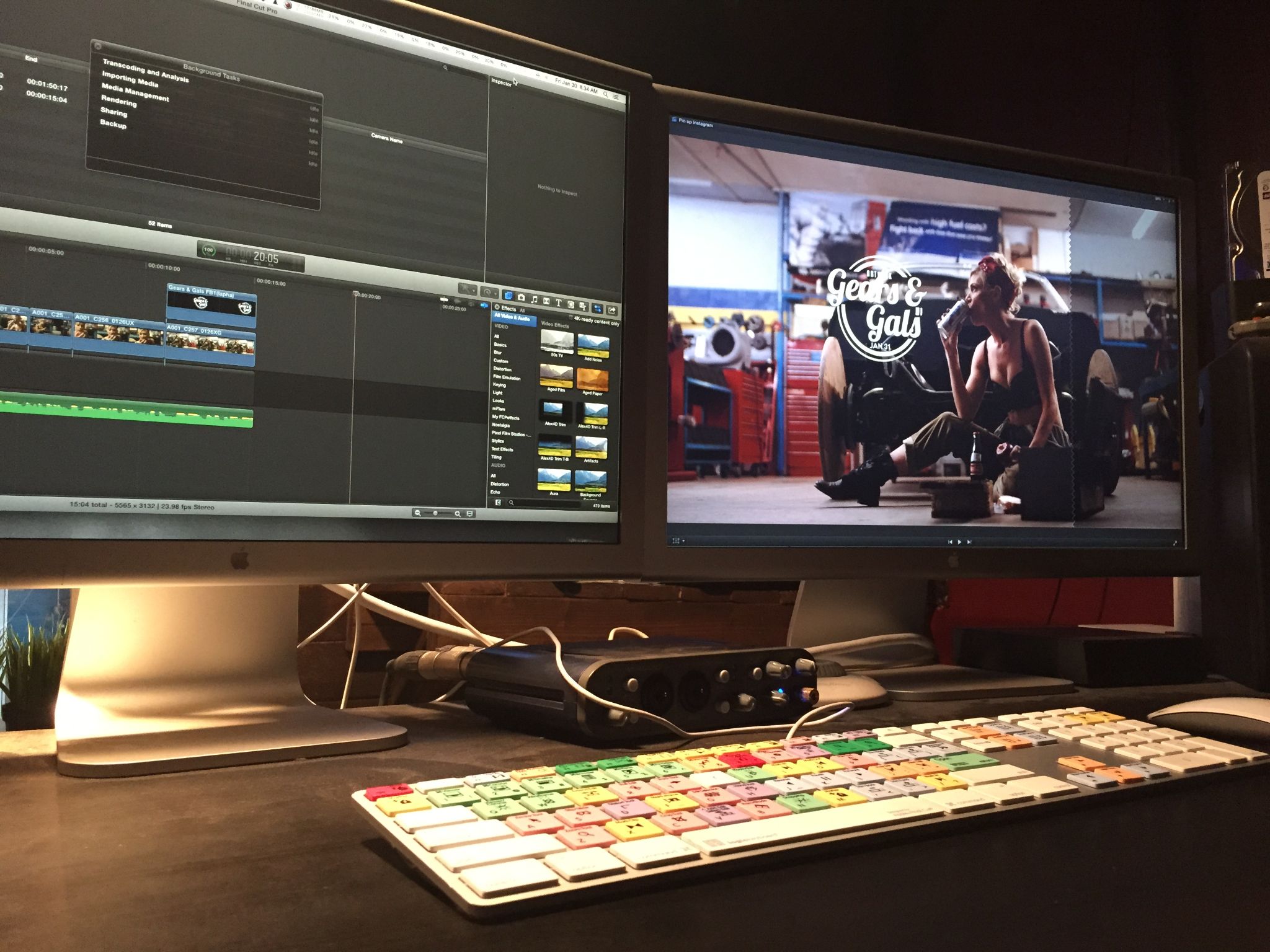 Closeup of two desktop monitors showing video editing software along with keyboard with colored buttons