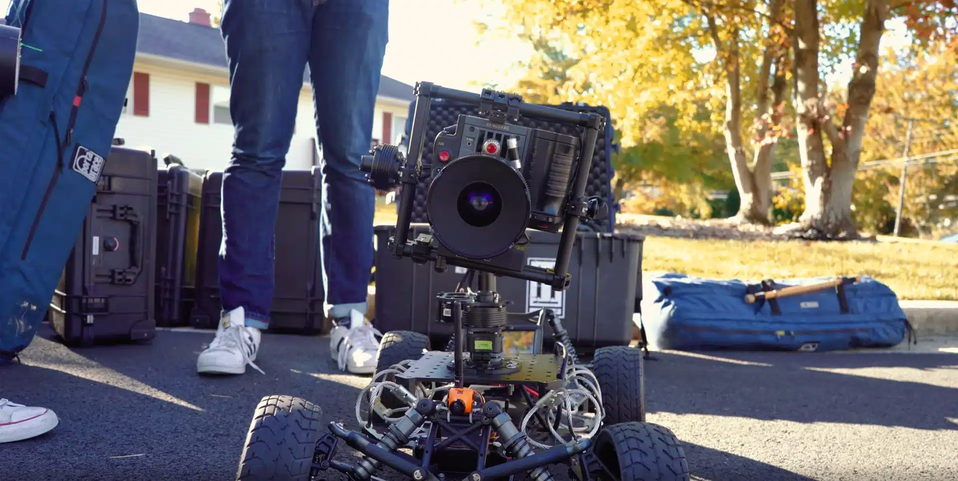 Closeup of video camera with two crew members standing nearby