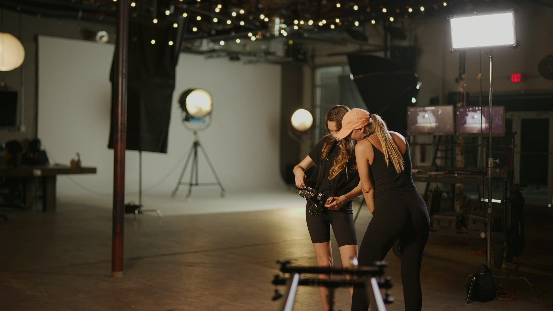 All-Dolled-Up Two female crew members looking at a camera on a set in a studio