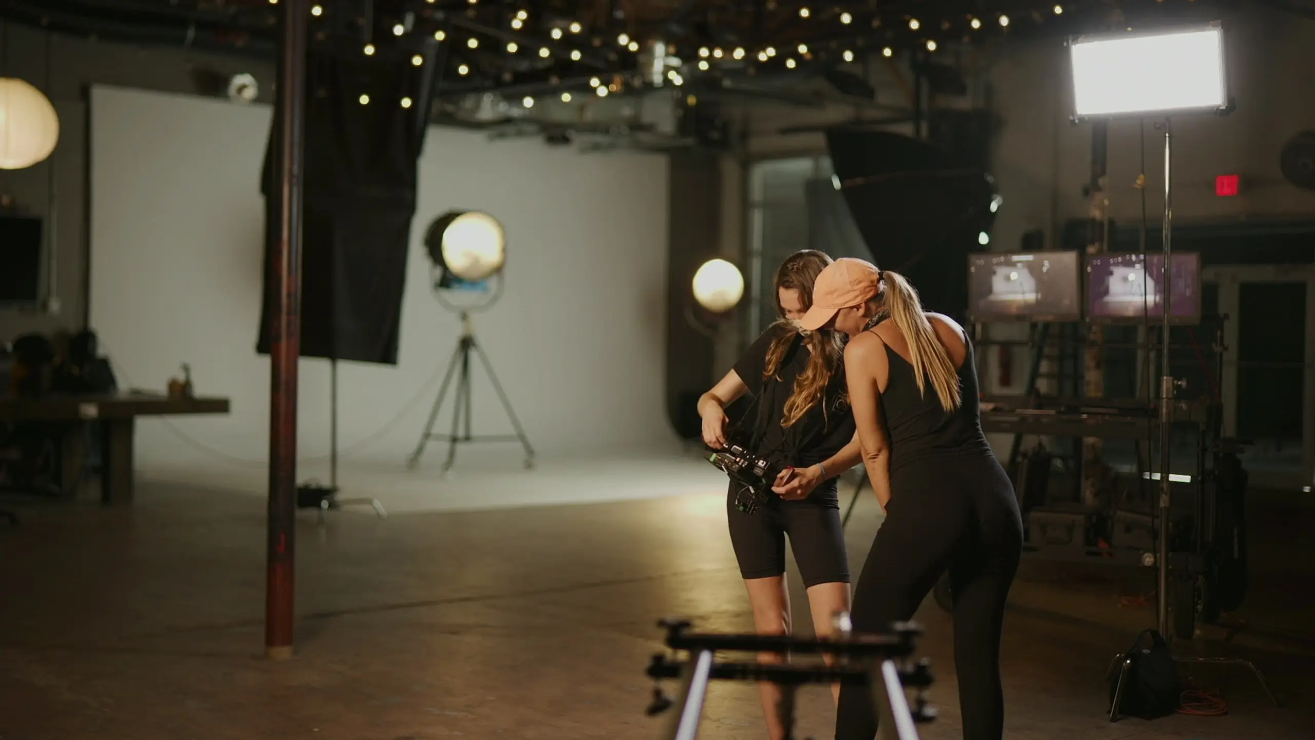 cis-page-all-dolled-up8 Two female crew members looking at a camera on a set in a studio