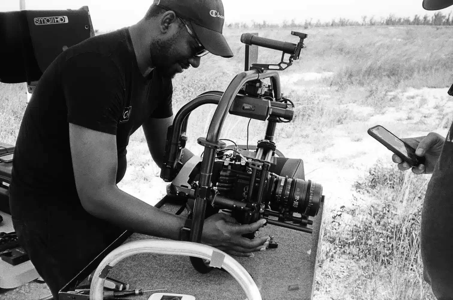 Black and white side profile of Joshua working with a video camera