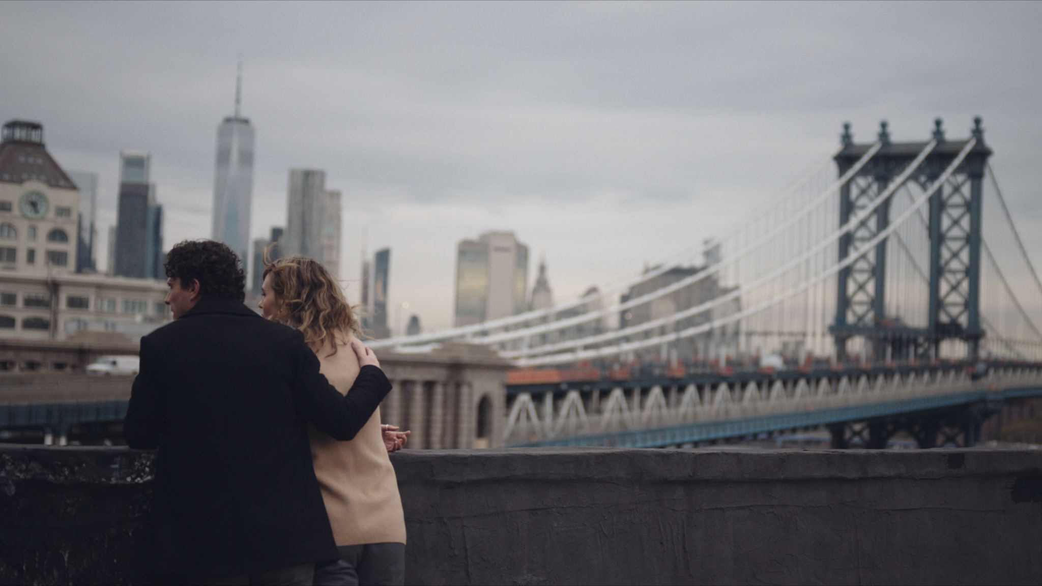 IU C&I Studios Page C&I Studios Blog The Rise of the Docuseries Are We in a Documentary Production Golden Age View from behind of man and woman on a bridge with the man's arms around the woman's shoulder looking out at another bridge in New York City