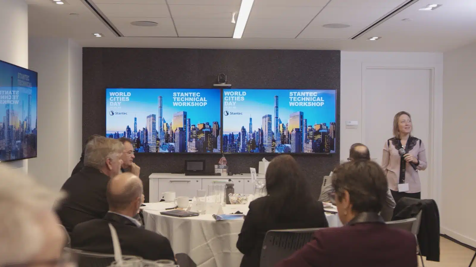 Livestream Dos and Donts Woman with microphone addressing a group of people in a video conference room