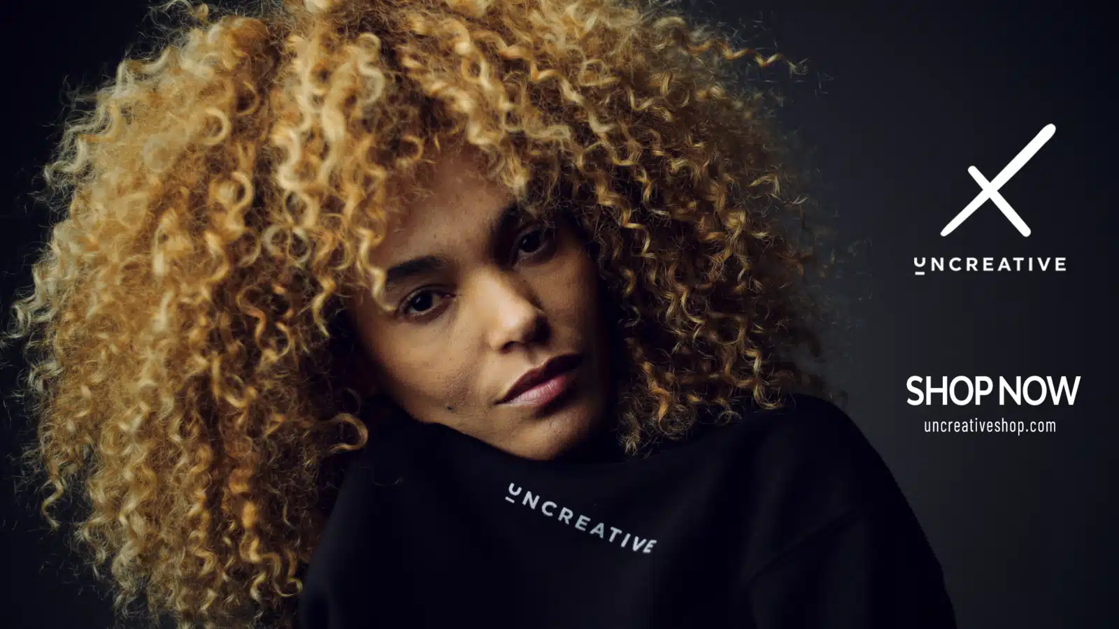 Headshot of woman with curly blond hair posing for the camera