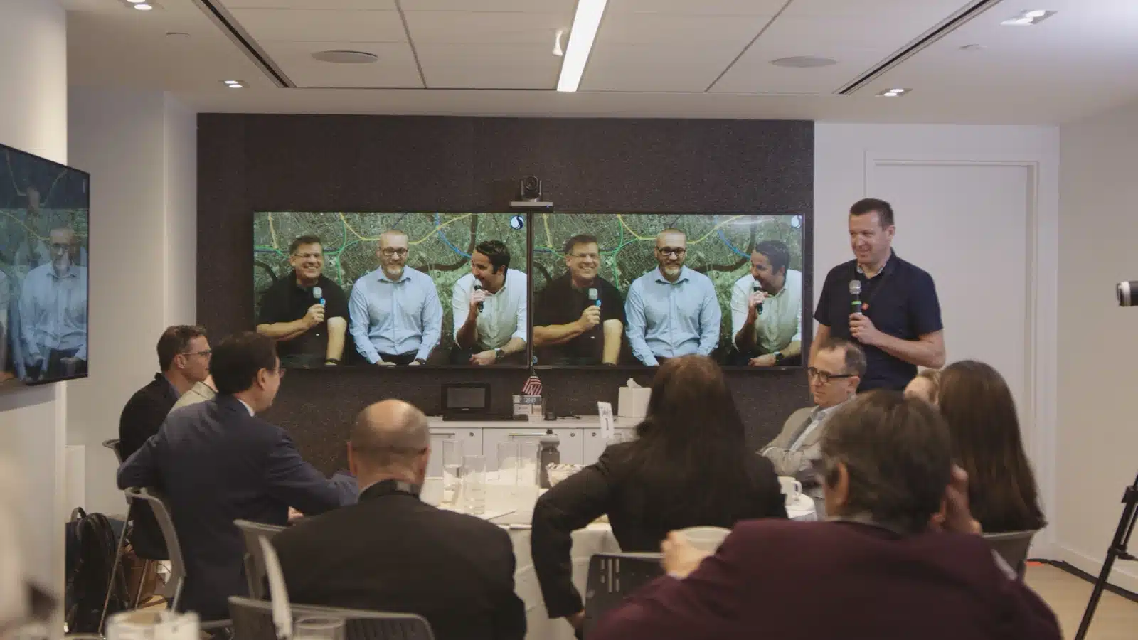 Livestream Corporate Event Man with microphone addressing a video conference room of people