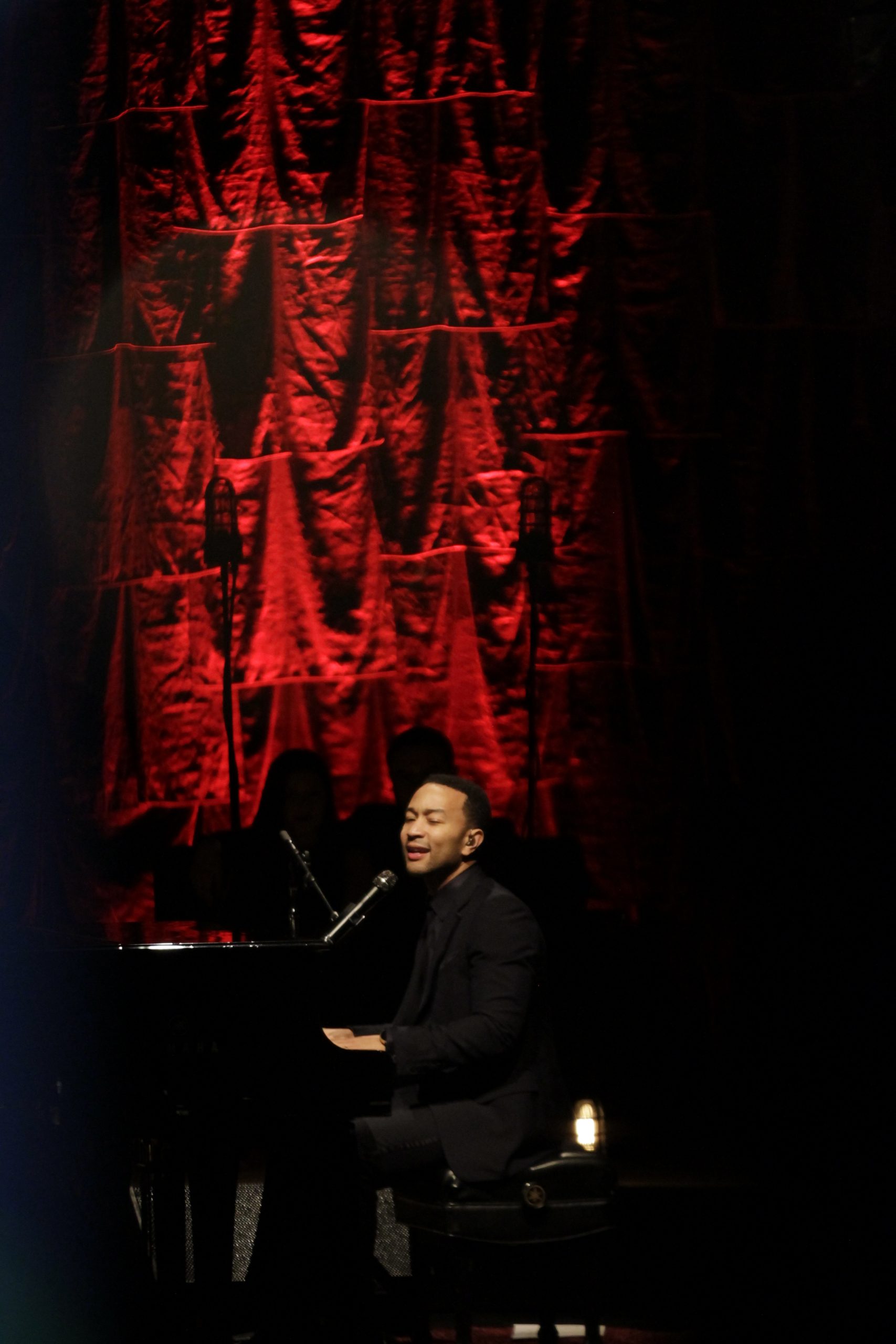 Side profile of John Legend performing in concert