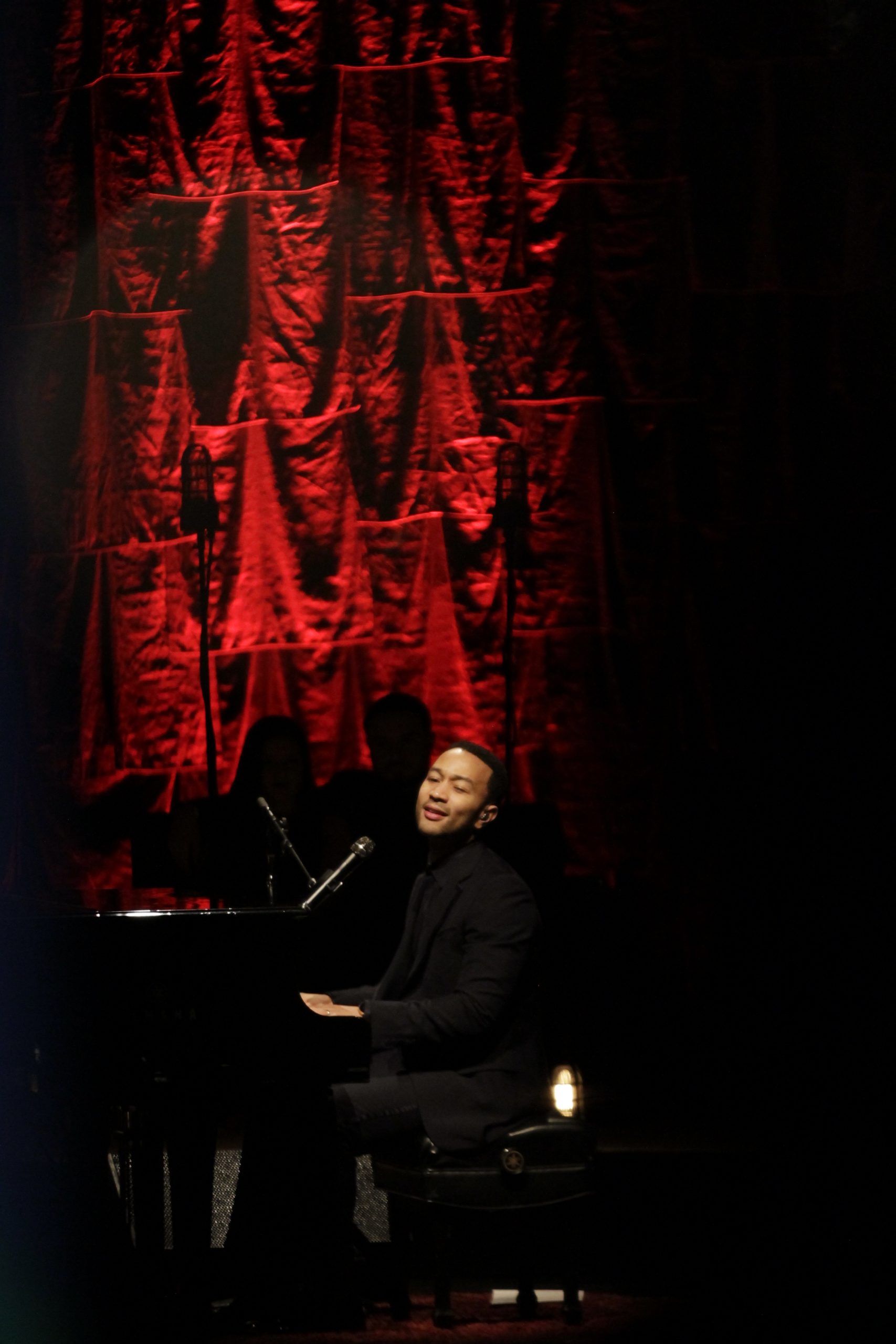 Side profile of John Legend performing in concert