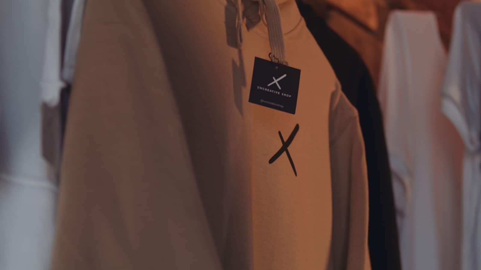 The Key Ingredients to Marketing an Ecomm Closeup of mustard colored Uncreative sweatshirt hanging in a store
