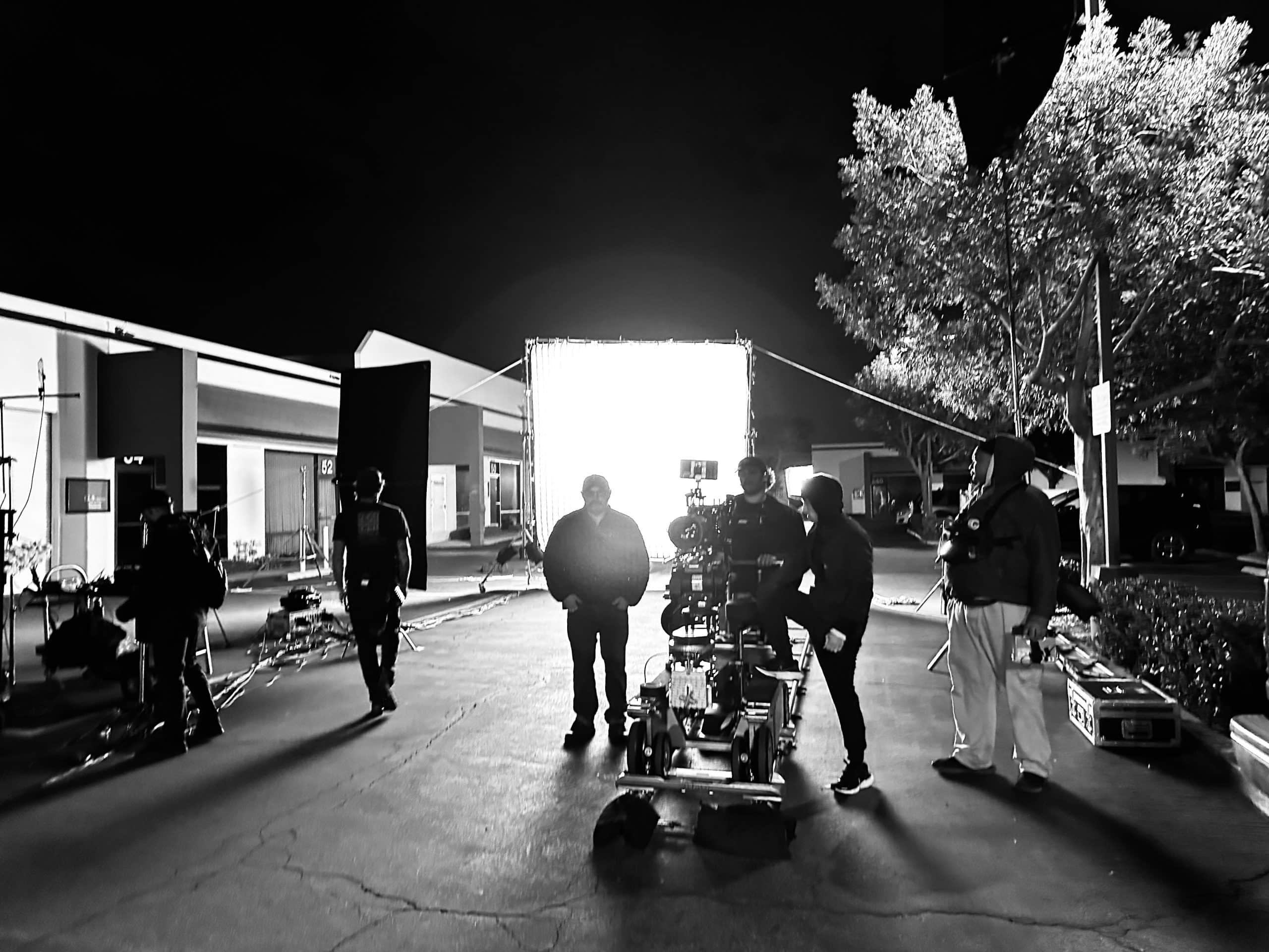 What is a Fixer Black and white of crew members working with a video camera on a set outside