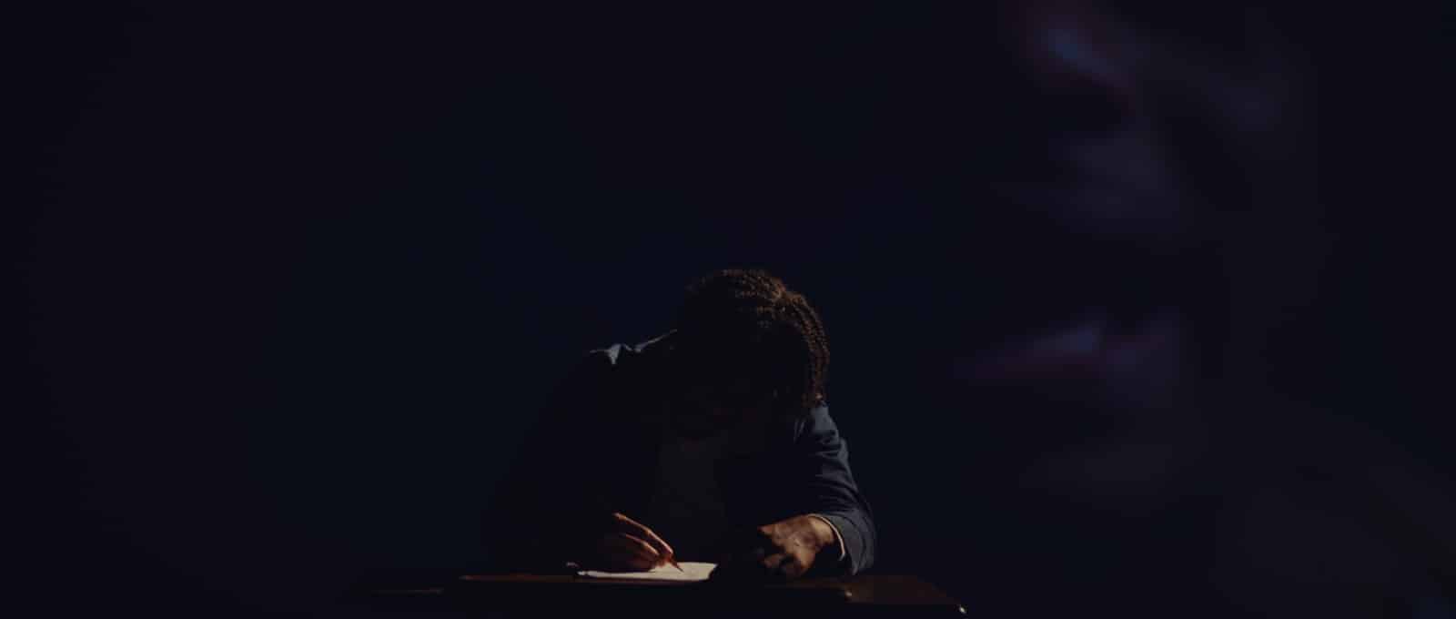 Man writing notes in semidarkness