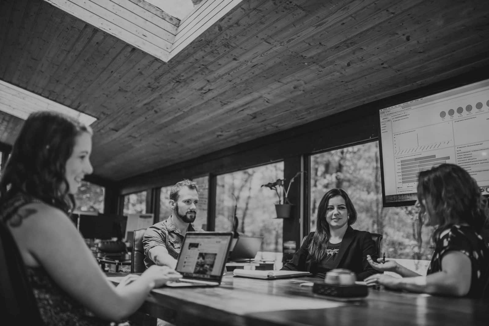 The Benefits of Working with a Diverse Team to Market your Brand Black and white of women talking to two other women and a man in a conference room