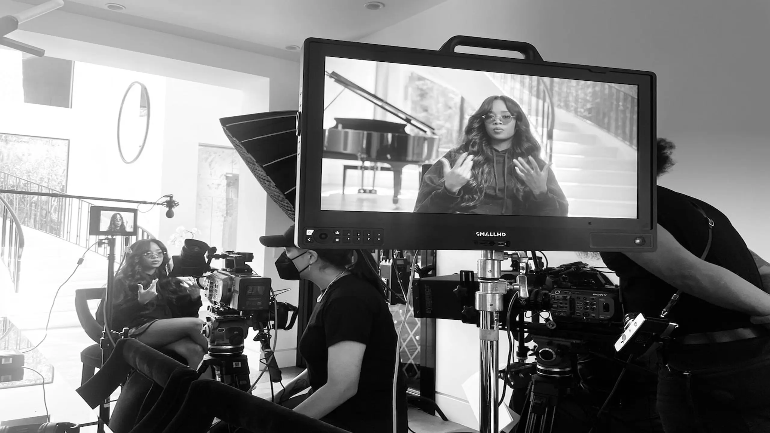 Black and white on set with crew and video camera in the foreground