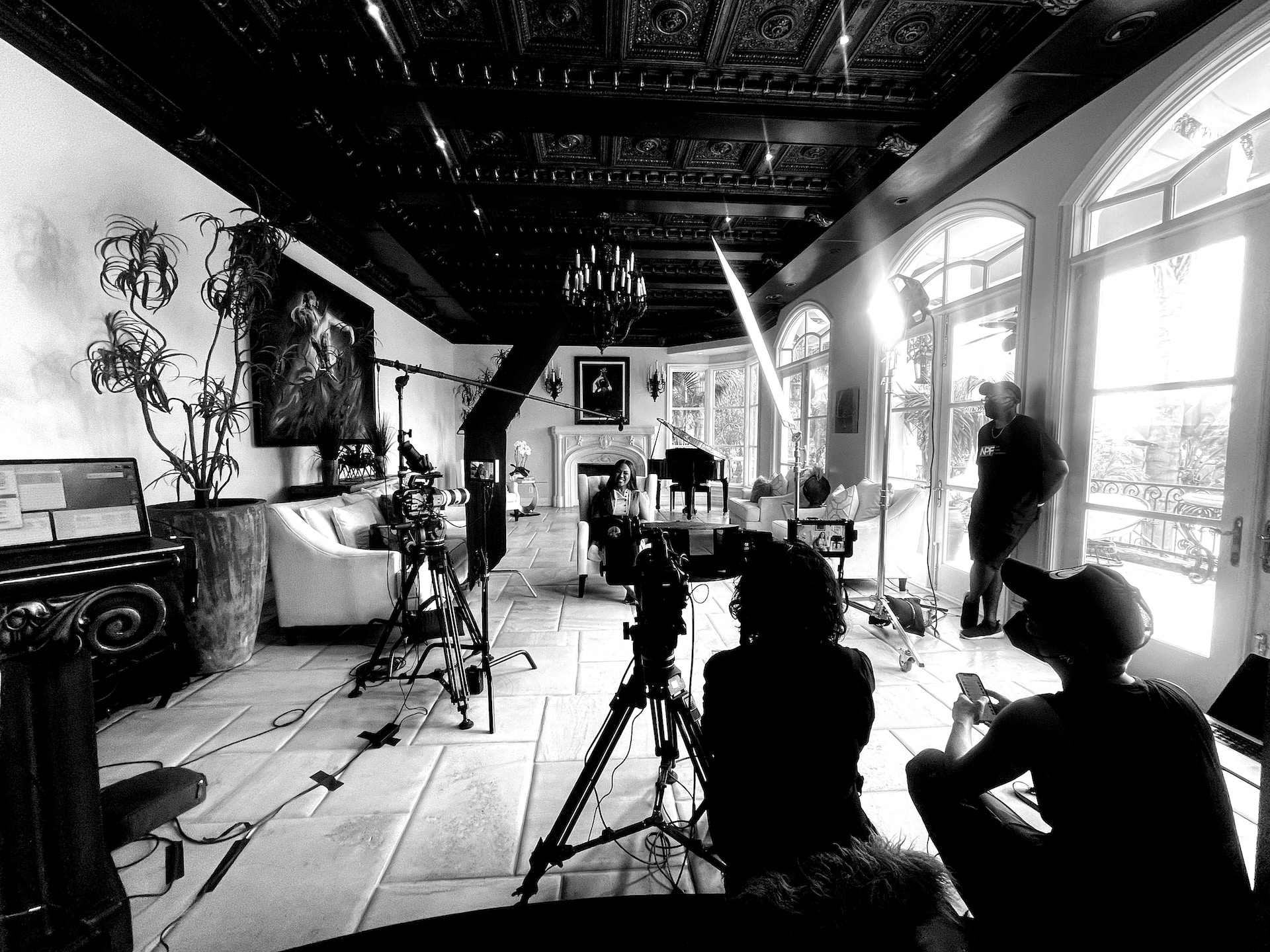 Erika Campbell sitting on a chair smiling with crew and equipment around