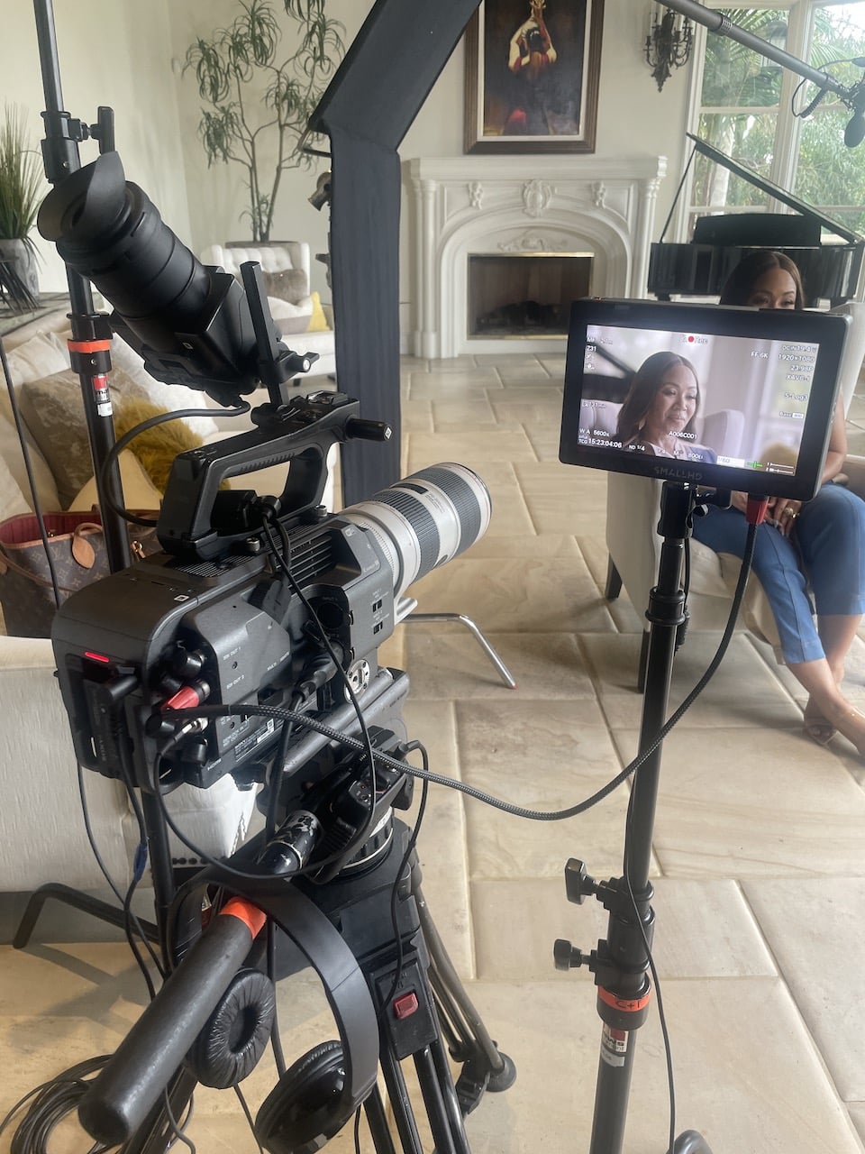 Erika Campbell on set with video display and video camera in the foreground