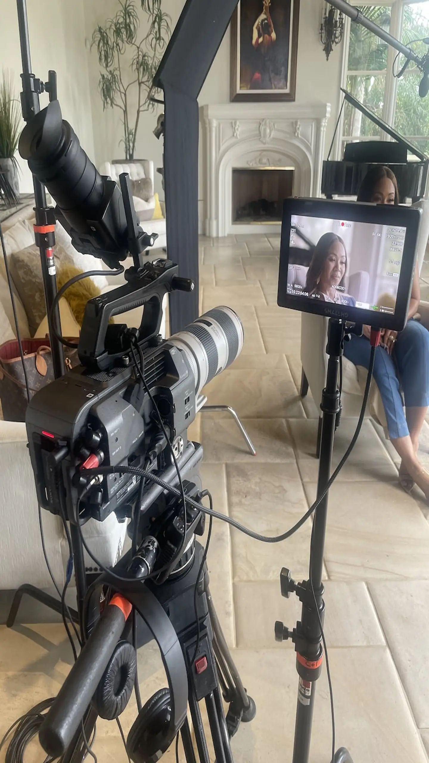Erika Campbell on set with video display and video camera in the foreground