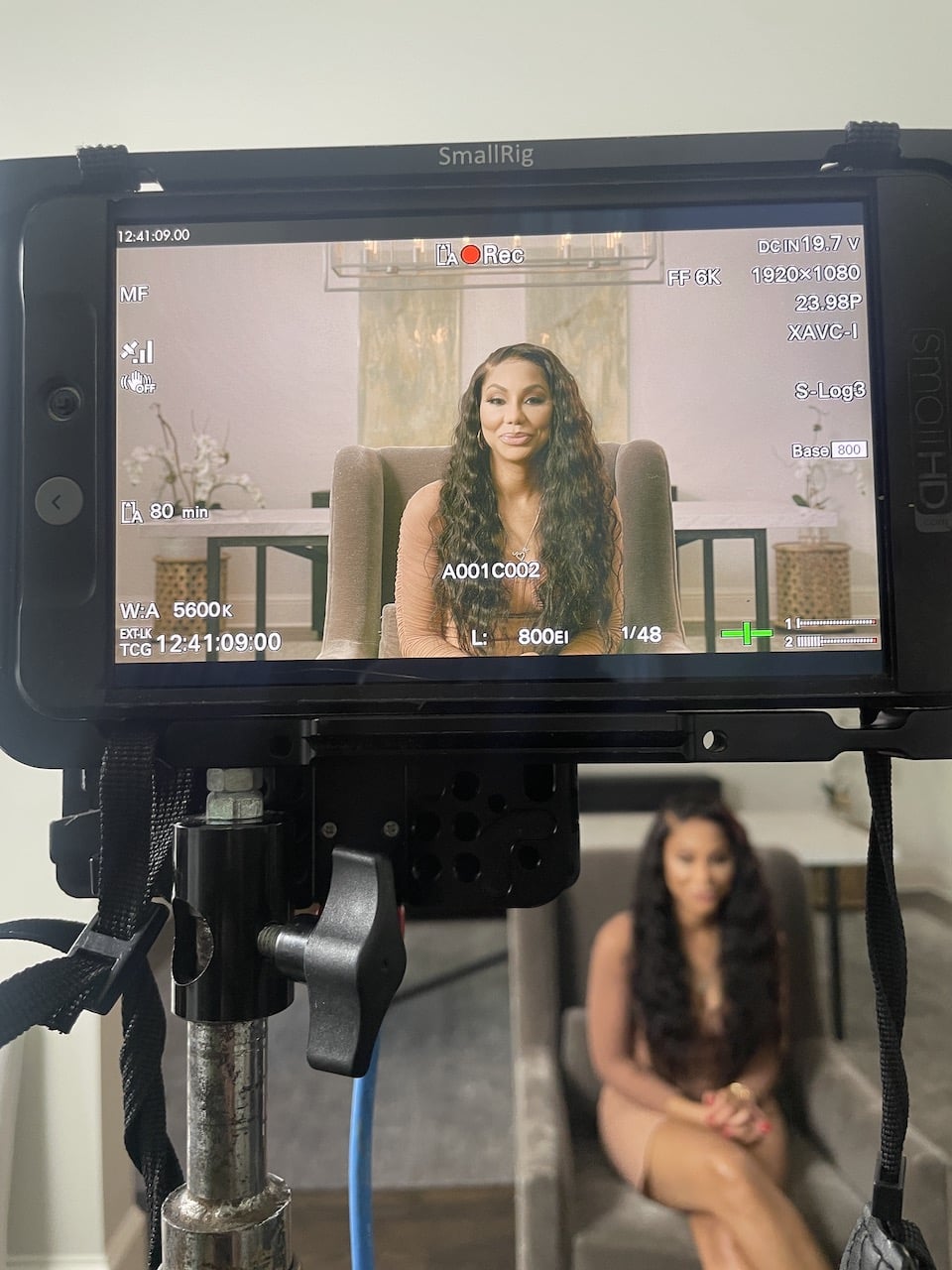 Closeup of video display monitor with Tamar Braxton in the background