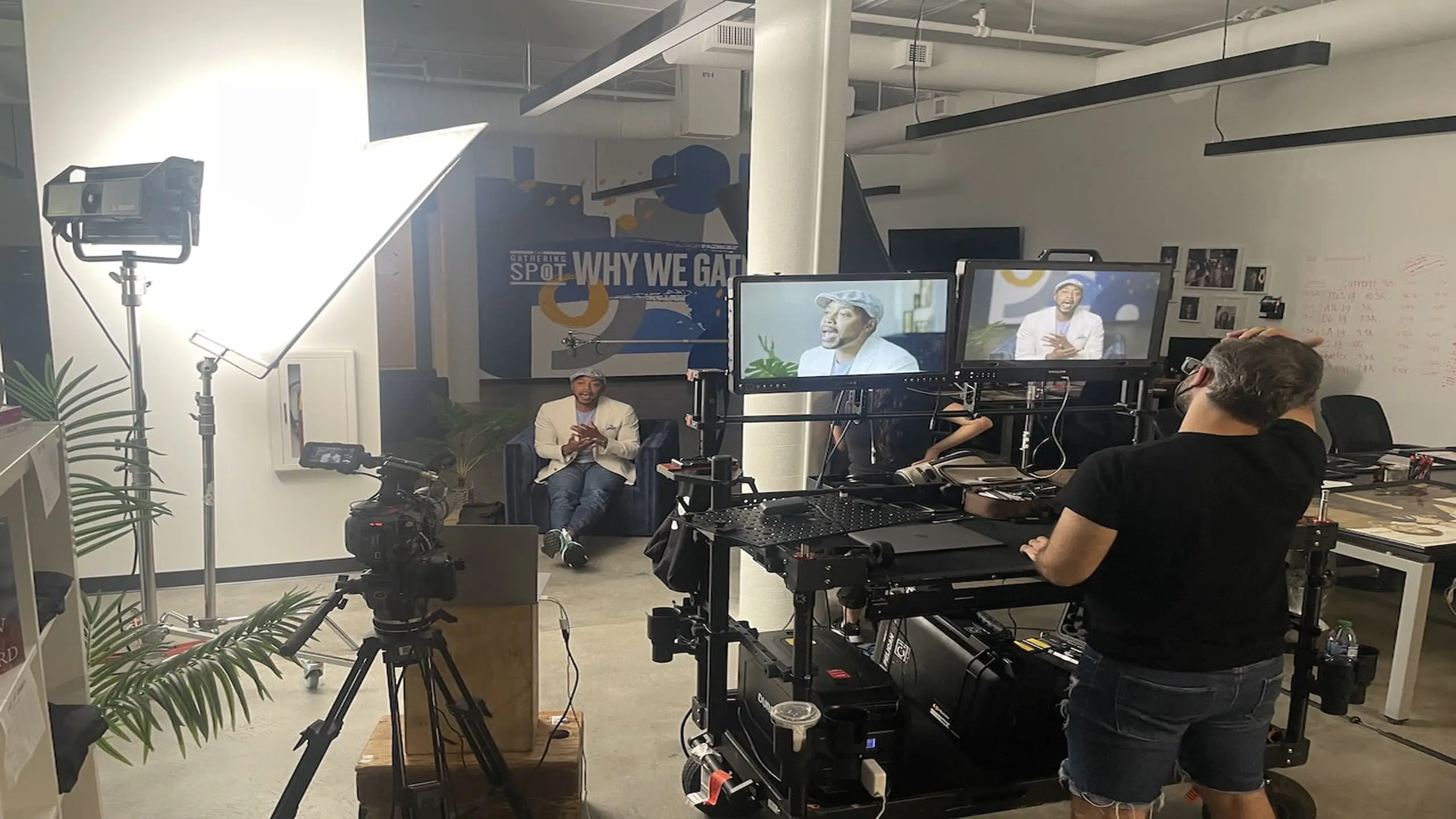 Will Packard sitting talking while being filmed by crew with equipment