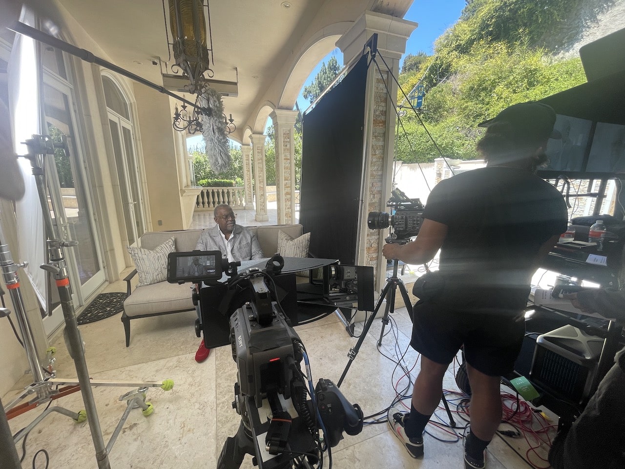 Dr. Todd Boyd sitting talking while being filmed by crew with equipment