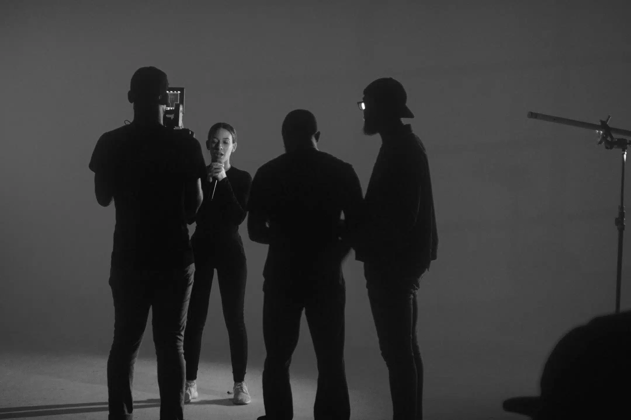 Black and white square Crew filming a female with microphone