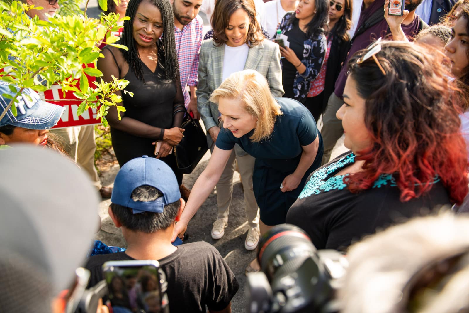 Woman with short blond hair interacting with people in a crowd