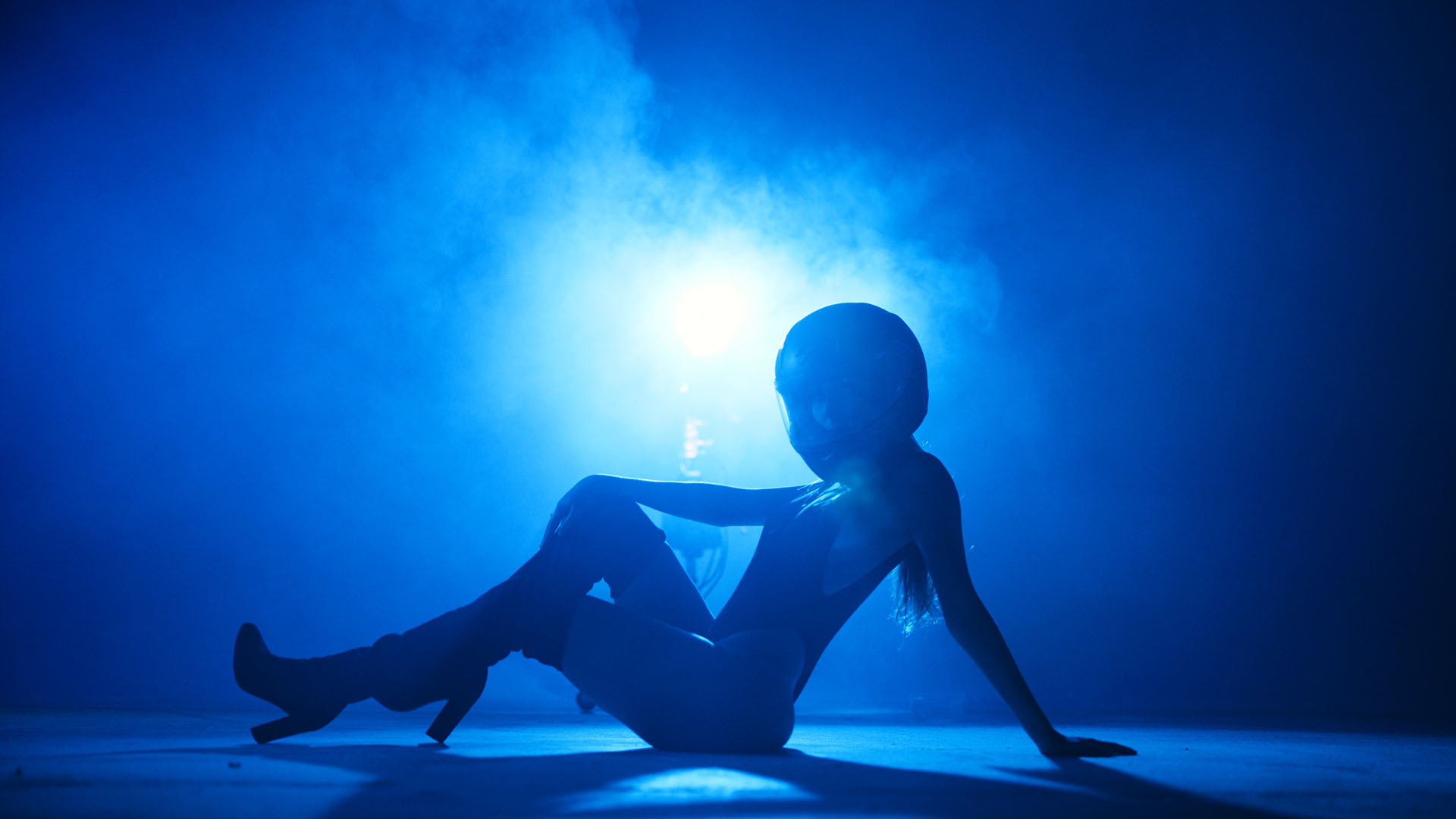 Beatriz Corbet with side profile of her in bluish light posing for the camera wearing a helmet