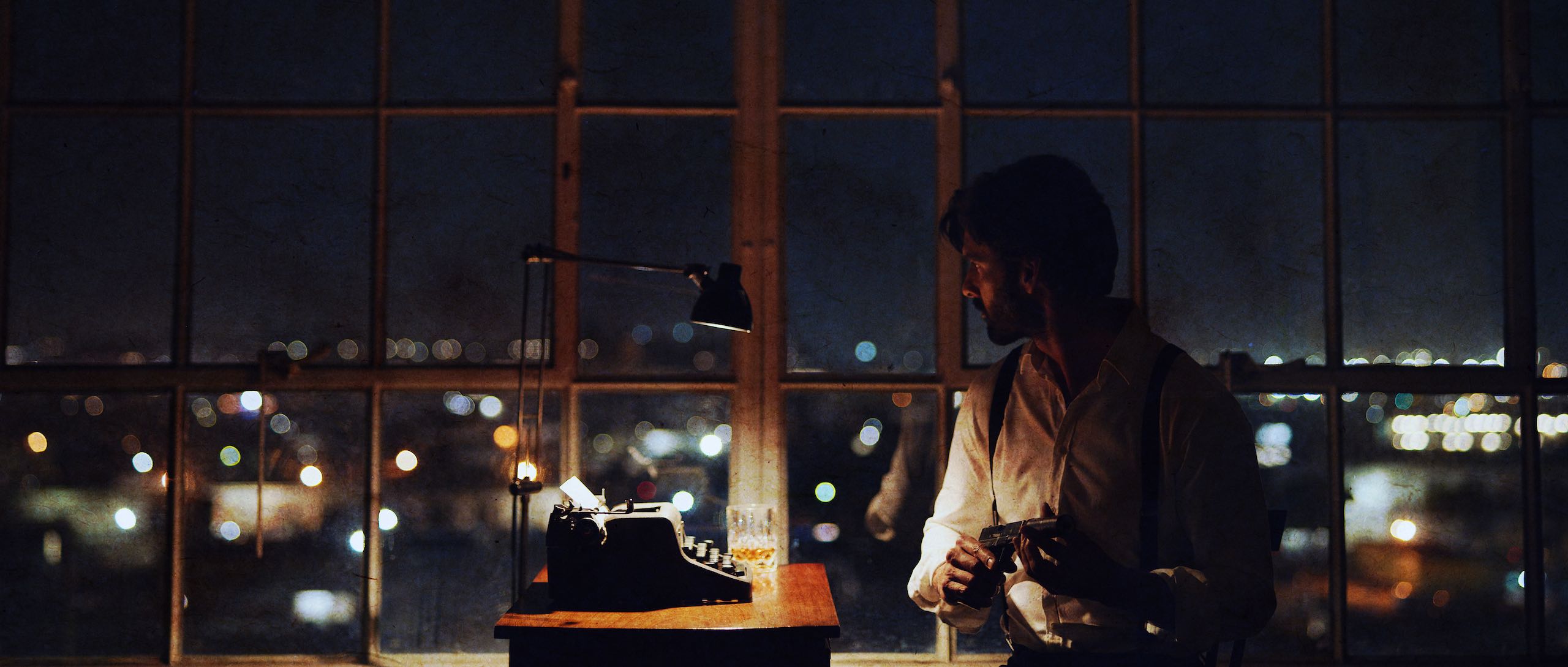 Side profile of a man sitting by a typewriter