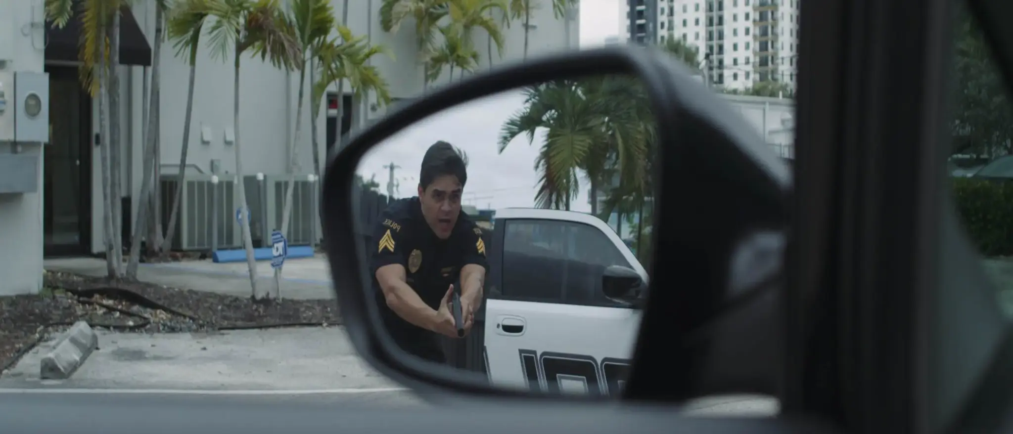 cis-page-tv-show-pitch13 View of cop in a car side mirror with gun drawn