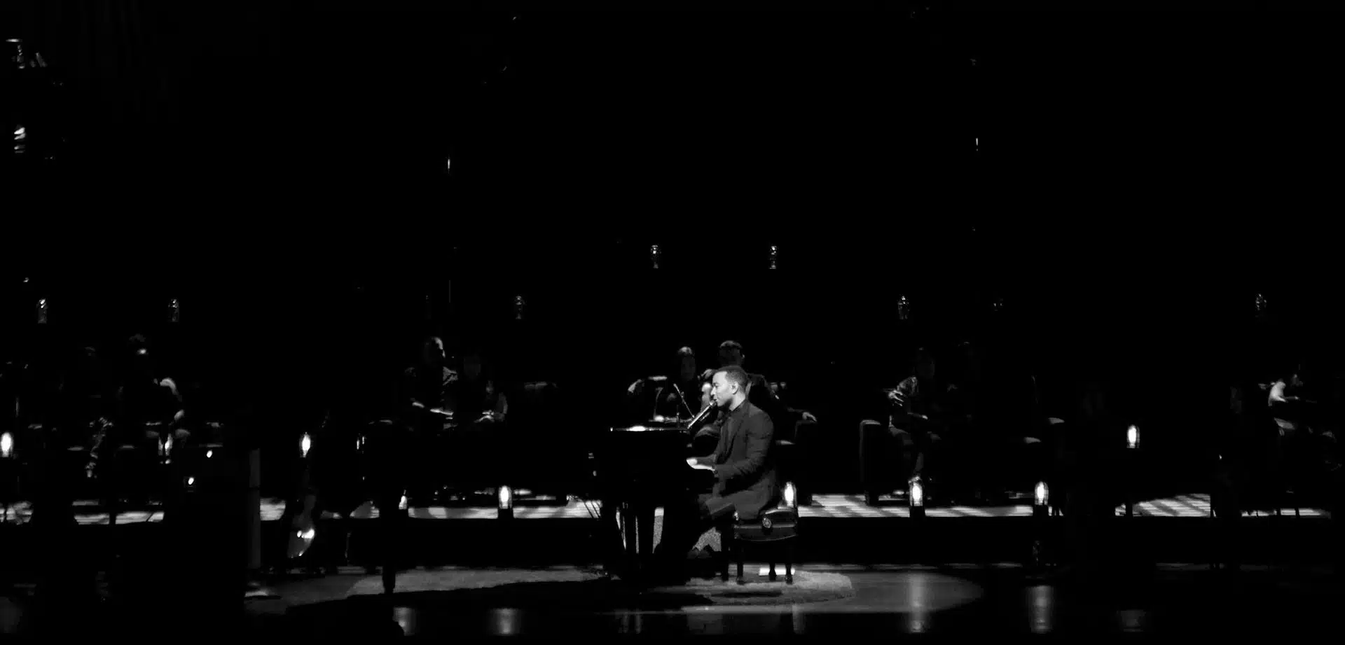 Black and white side profile of John Legend on stage