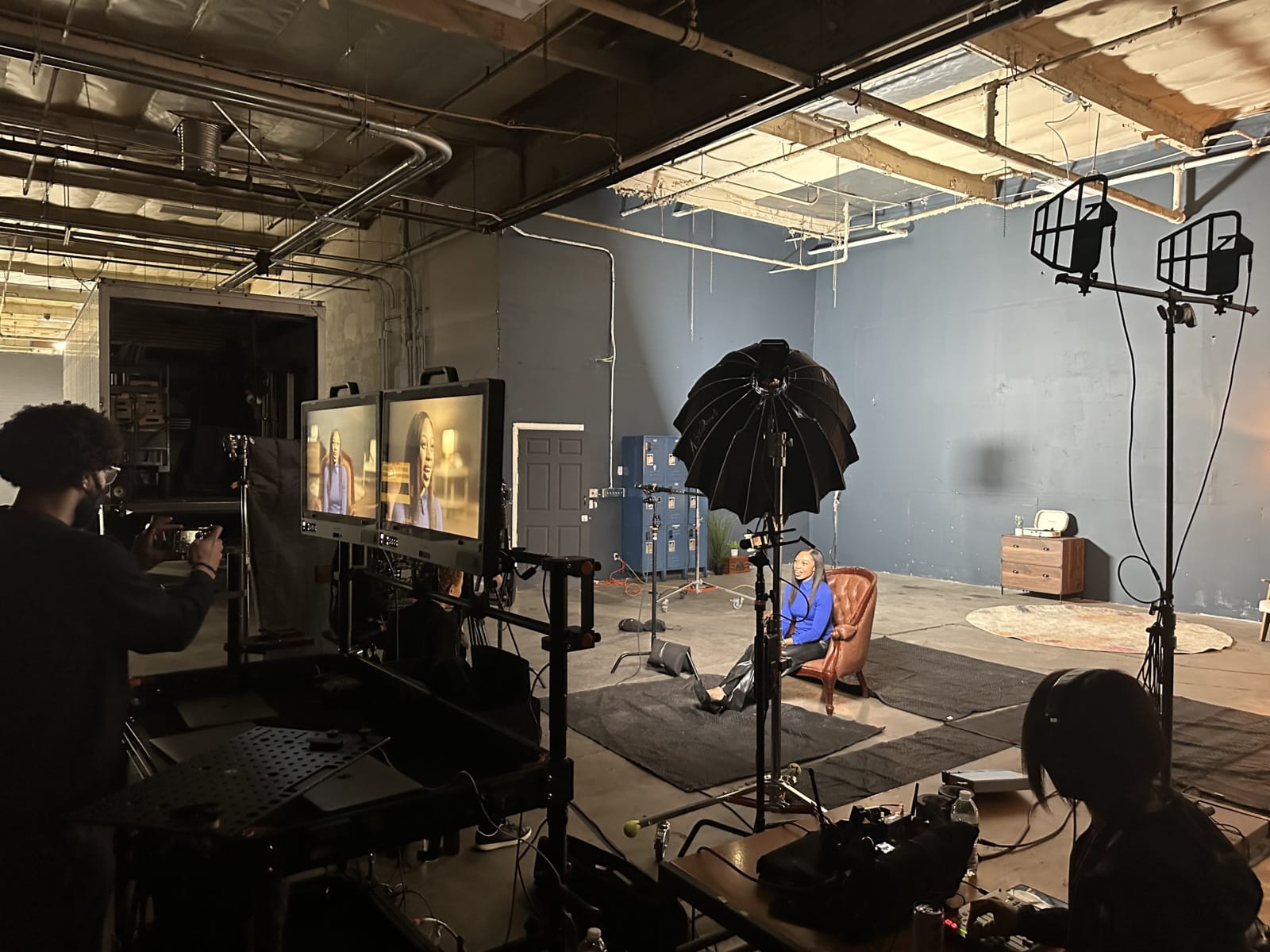 Woman wearing blue sweater on set with crew