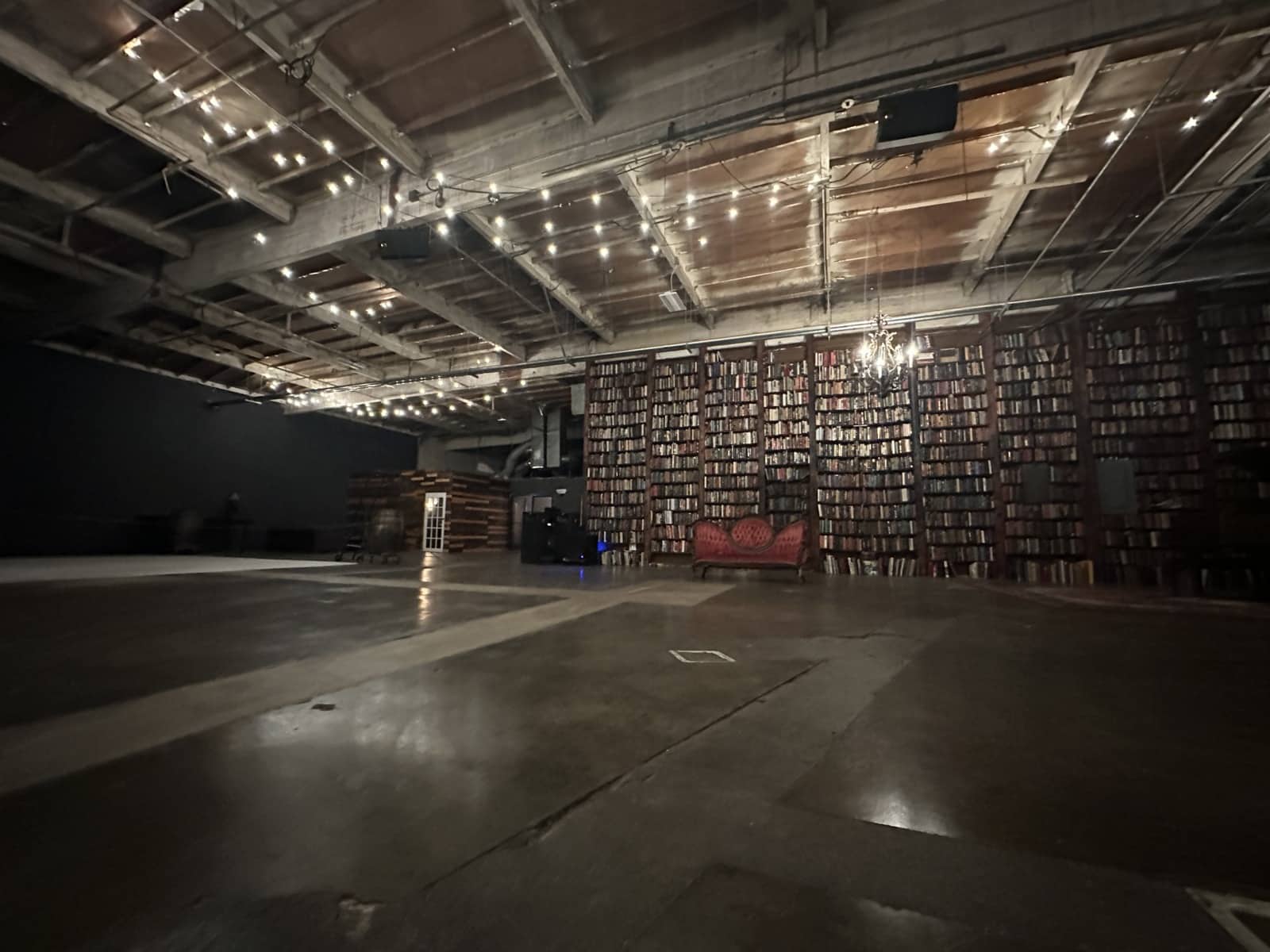 Red velvet vintage couch against bookshelves of books