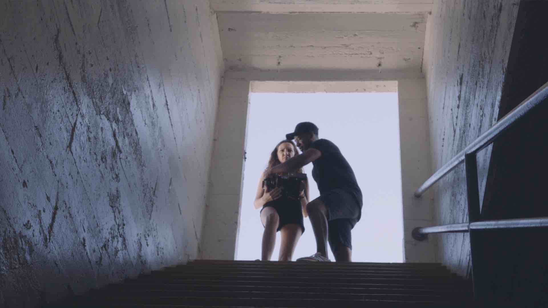 Man with a girl at the top of the stairs looking down