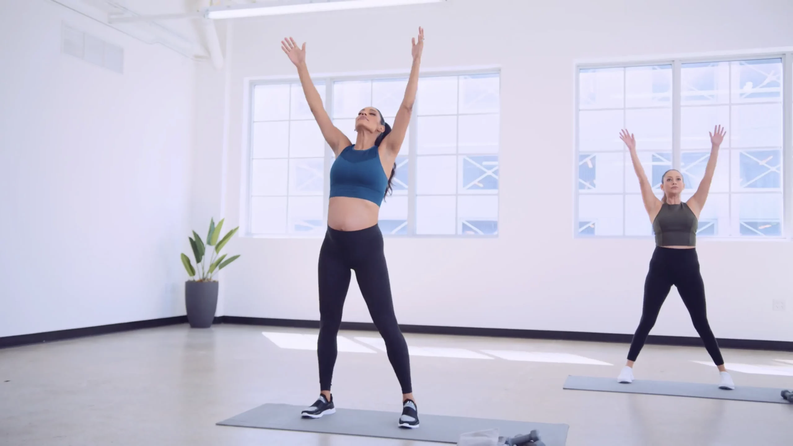 Two female exercisers doing body stretching