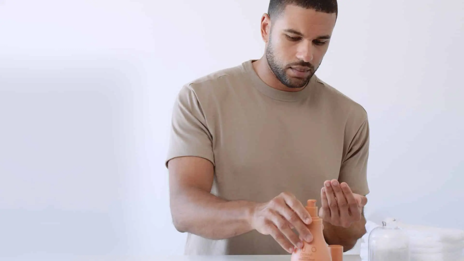 Image of man getting some lotion from a container