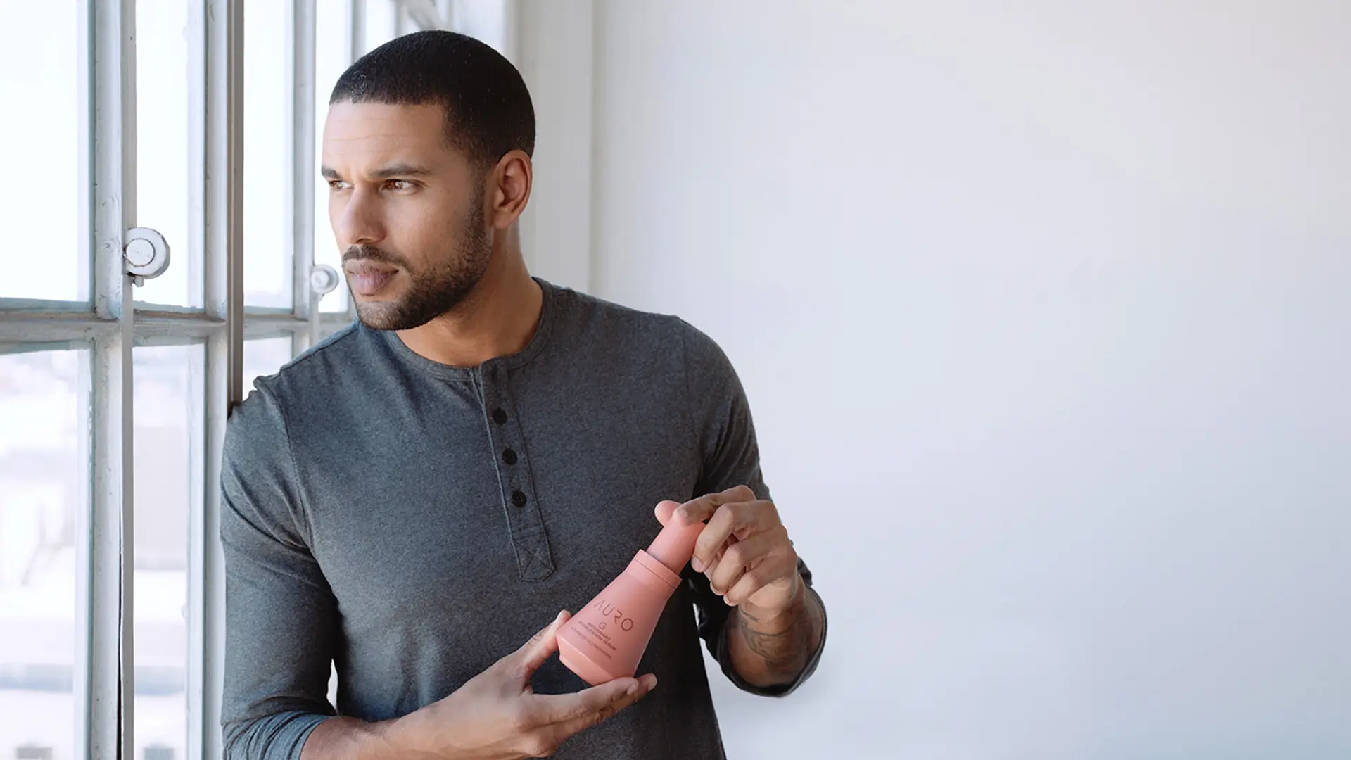 Young man holding Auro Skincare bottle