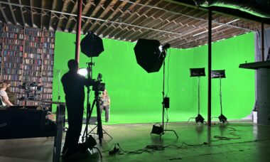 Crew setting up equipment in studio rental with green screen