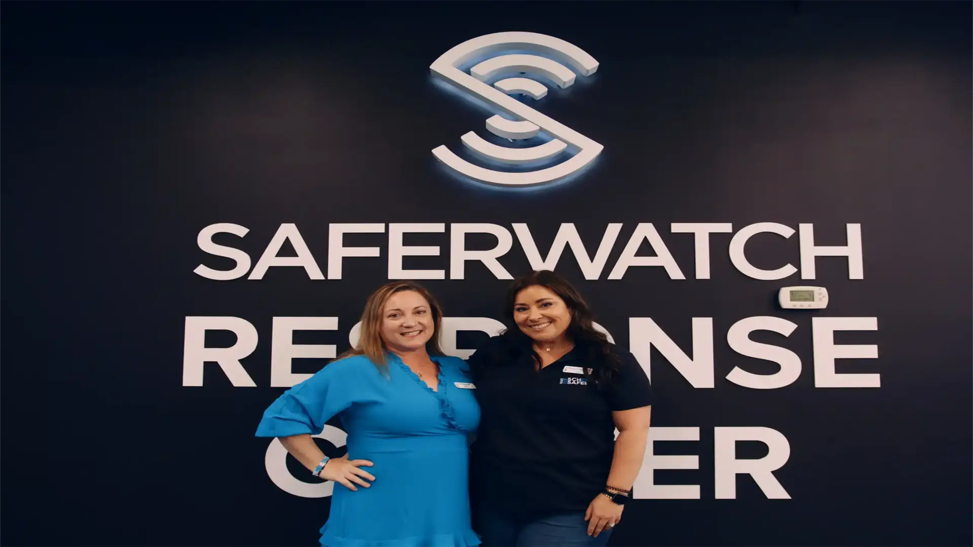 SaferWatch 7 Two women posing in front of SaferWatch sign